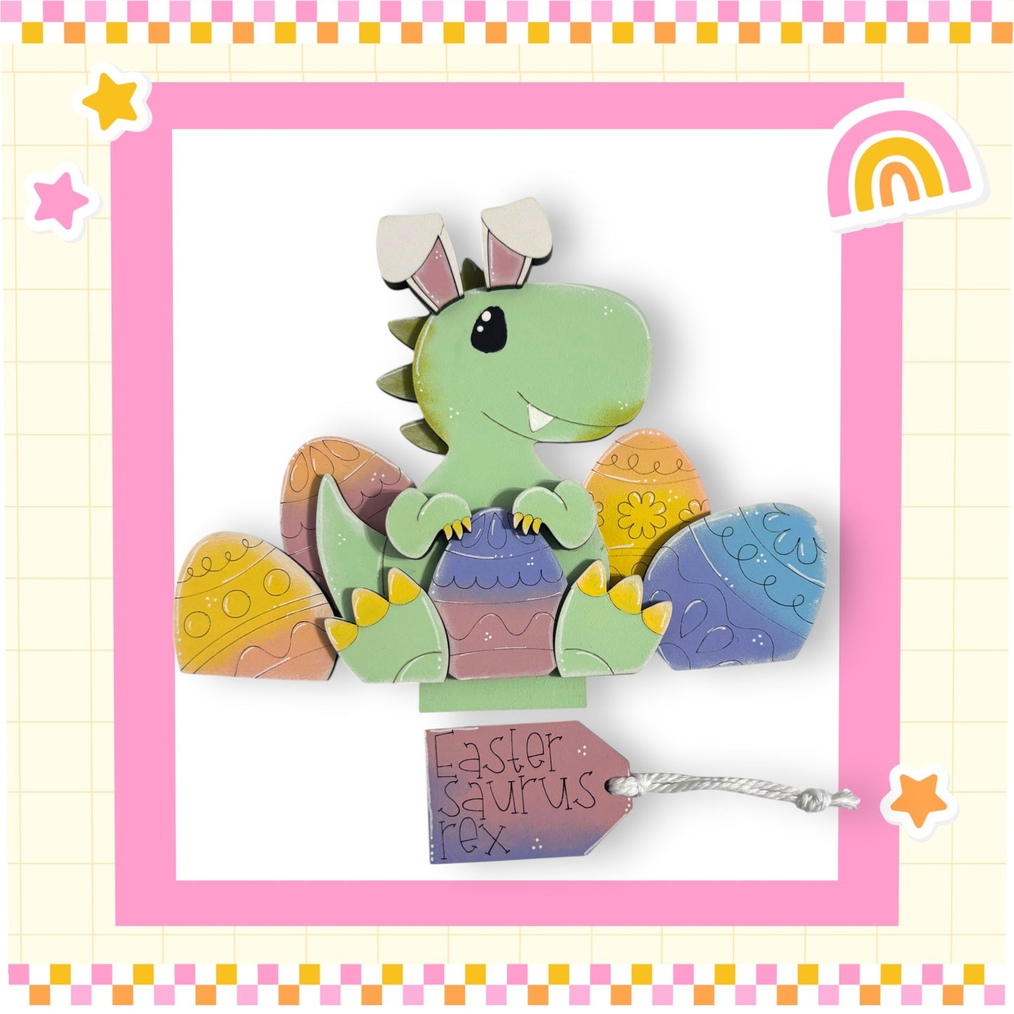 A green dinosaur toy is sitting on top of a pile of colorful Easter eggs, with a tag attached to the dinosaur that reads "Easter dinosaur Rex".