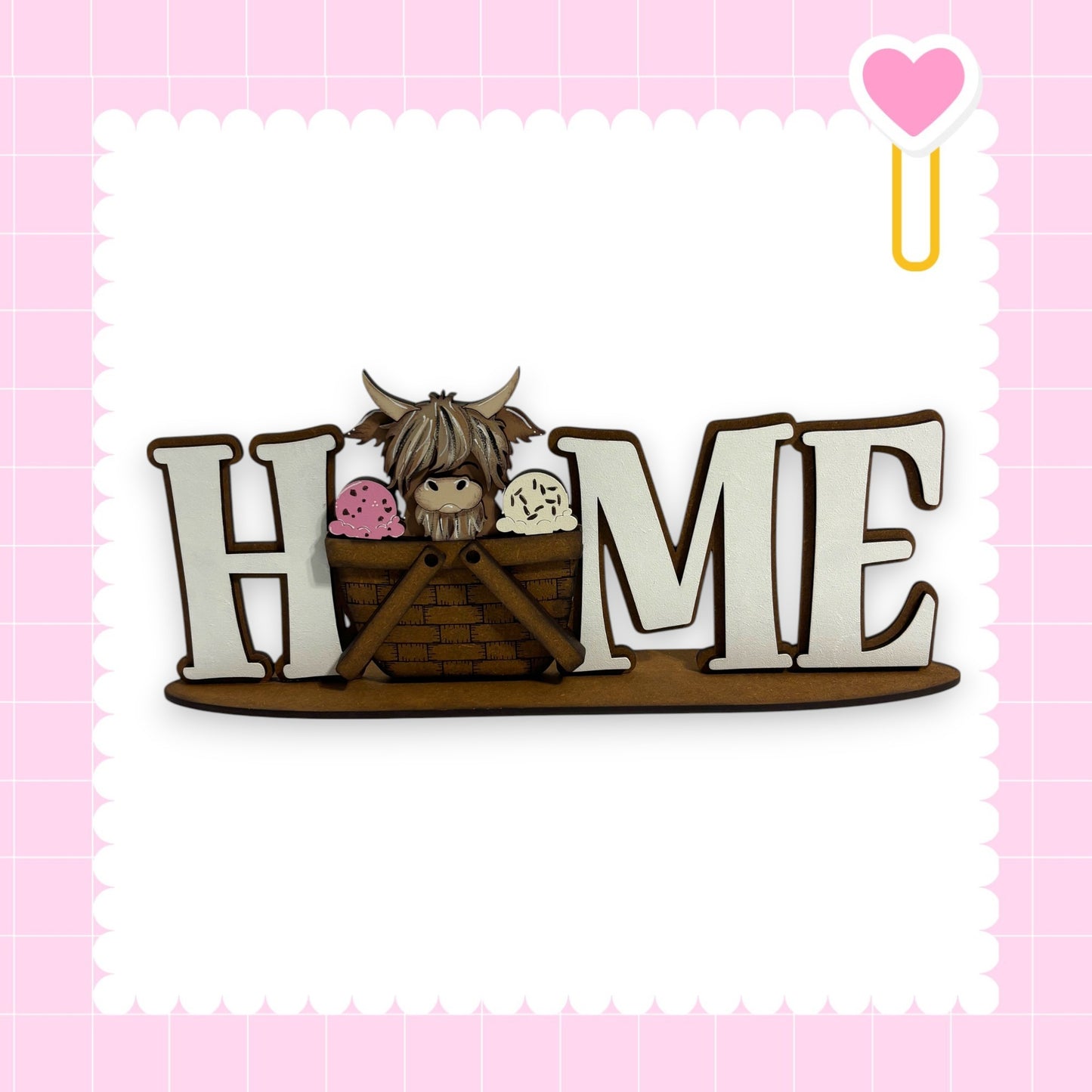 A wooden sign with the word "HOME" in large letters, featuring a cute cartoon character inside a basket.