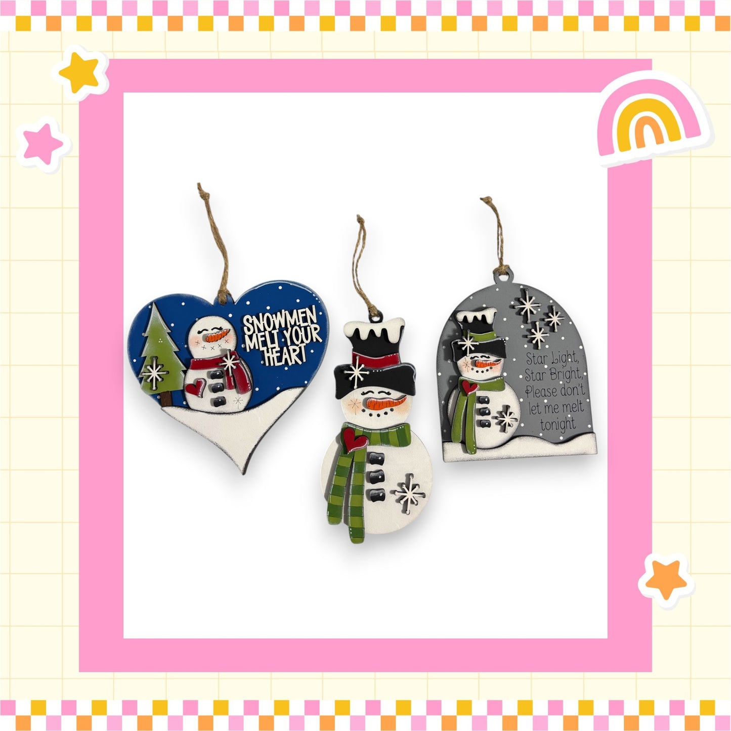 three snowman ornaments hanging on a pink and yellow checkered border.