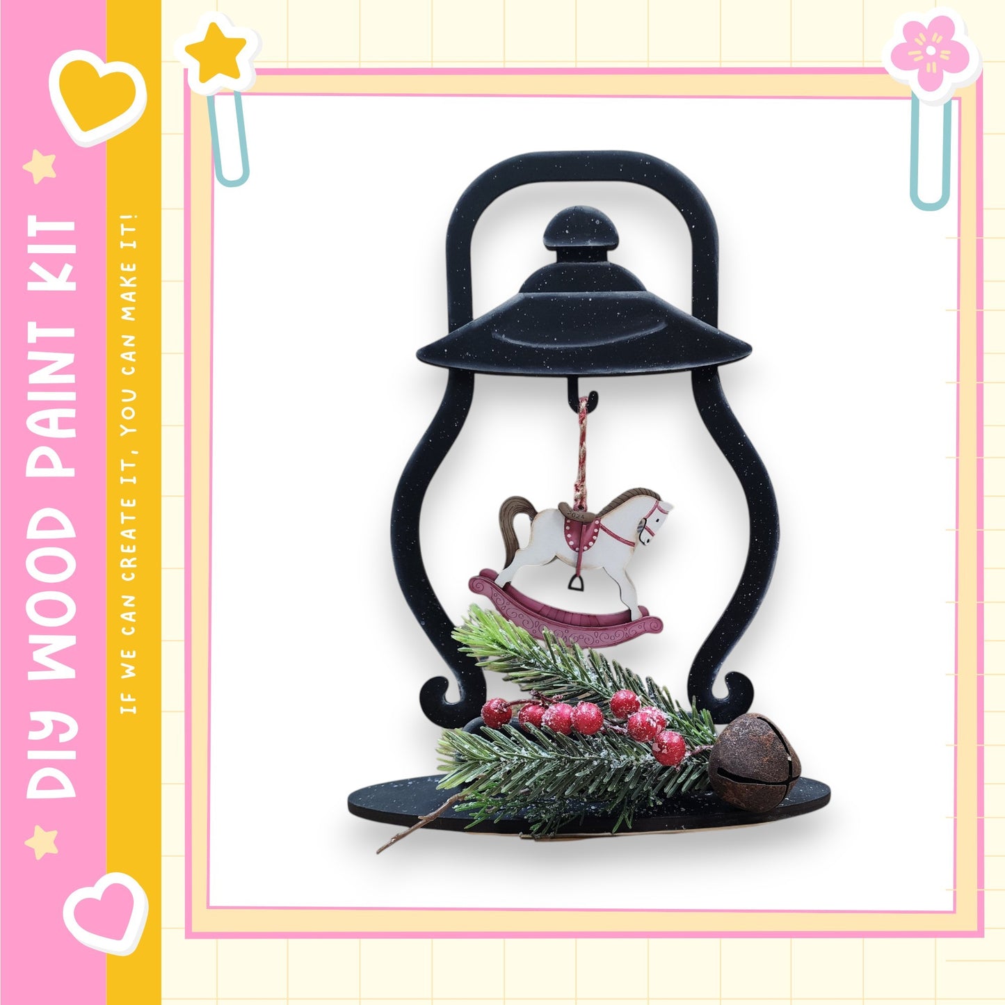 A black lantern with a white rocking horse ornament hanging from it, placed on a black base with a pine branch and red berries.