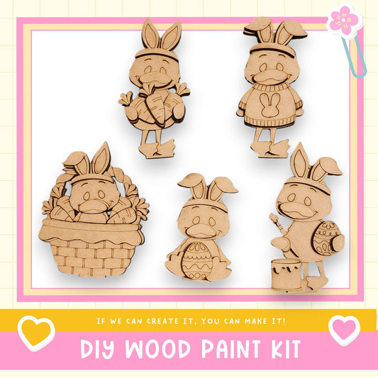 The image is a DIY wood paint kit featuring five wooden Easter bunny characters in various poses, including one in a basket, one holding an egg, and one holding a paintbrush.