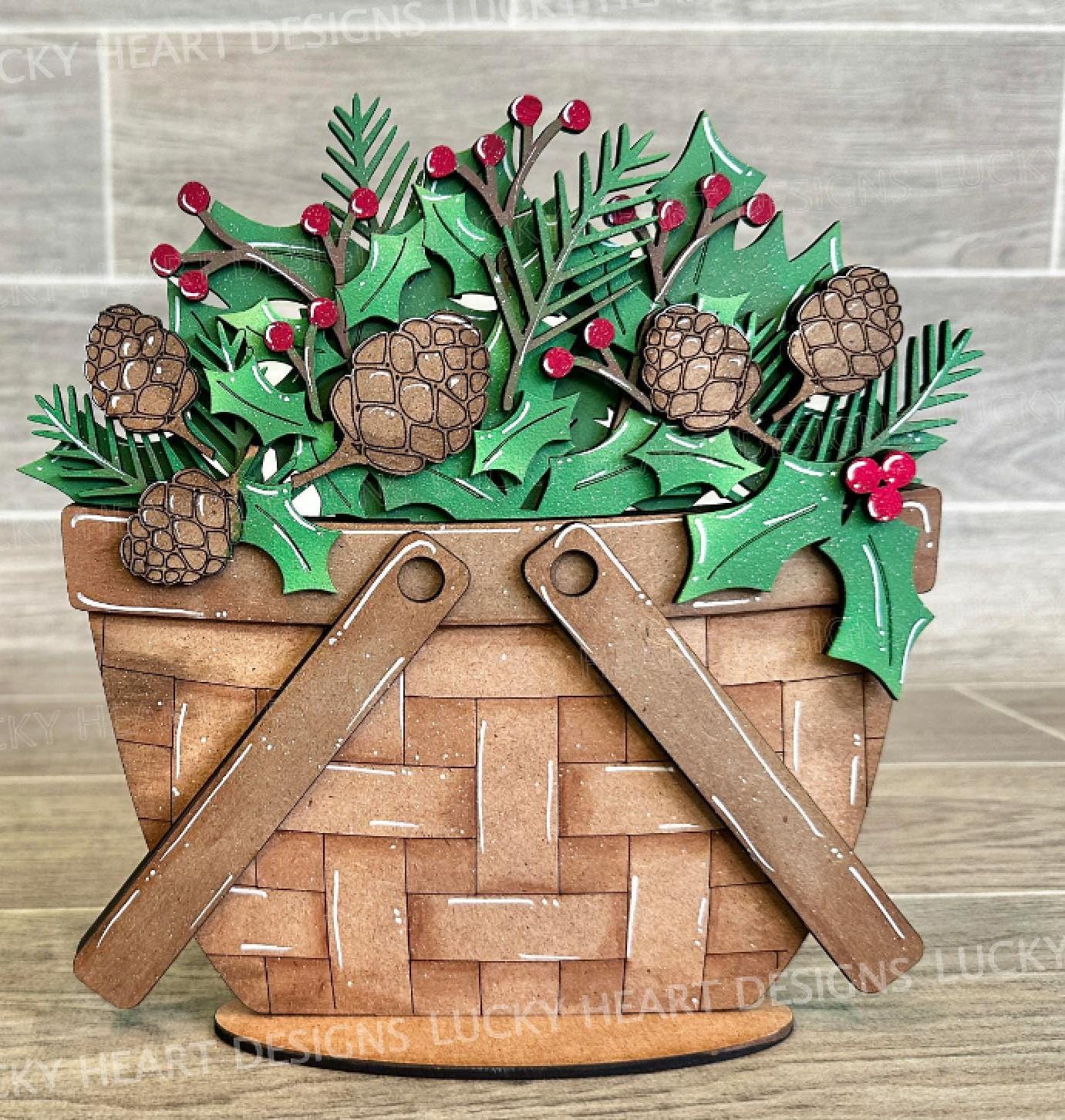 A wooden basket with a wicker basket handle, filled with pine cones, holly leaves, and red berries, placed on a wooden surface.