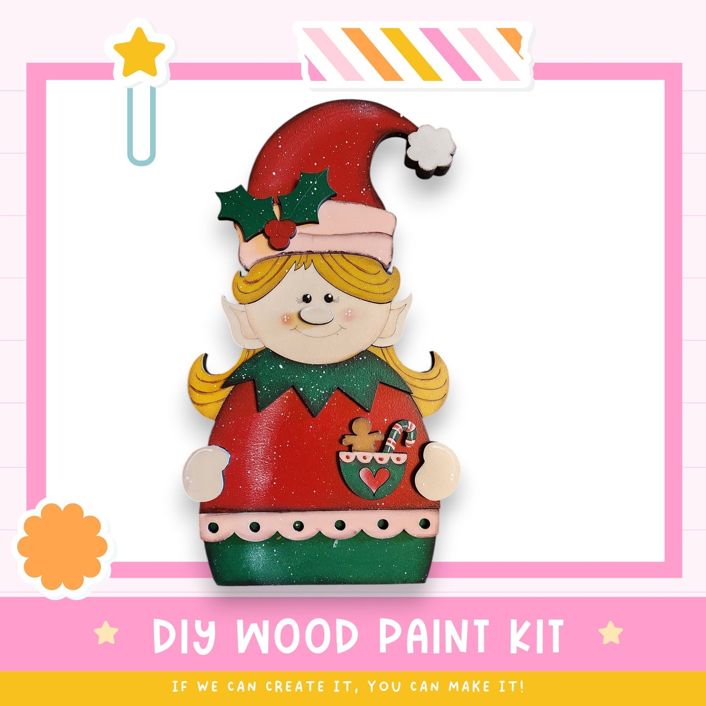 a wooden elf figure wearing a red sweater and green hat, holding a gingerbread man figure. The elf is wearing a red and green outfit with a green bow on its head. The image is a DIY wood paint kit, and the text encourages creating the kit if one can.