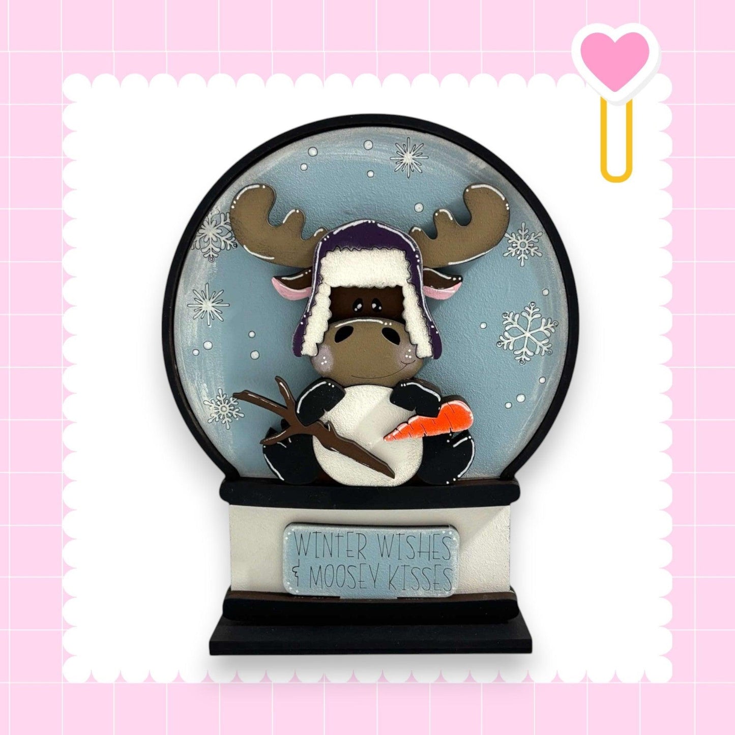 a snow globe with a moose wearing a hat