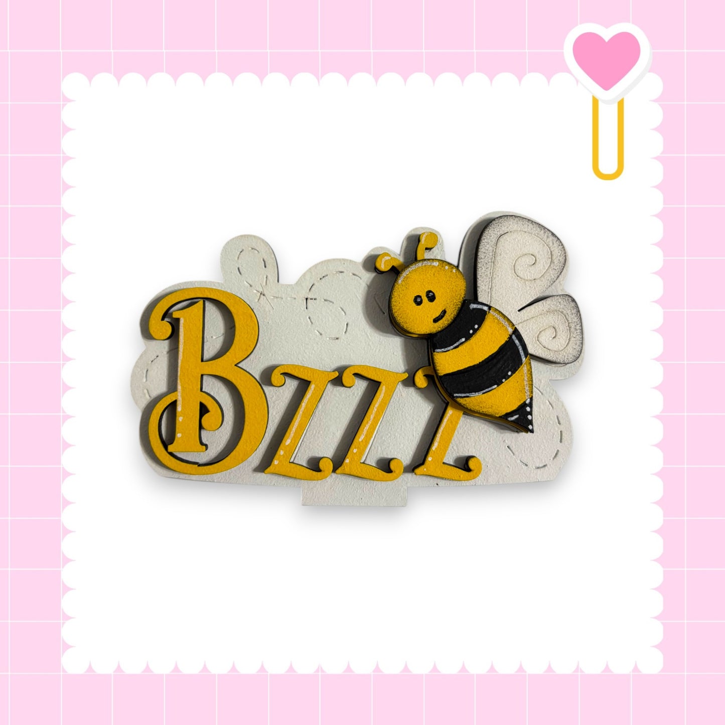 A wooden sign with the name "BZZZ" in large yellow letters, featuring a bee-like design.