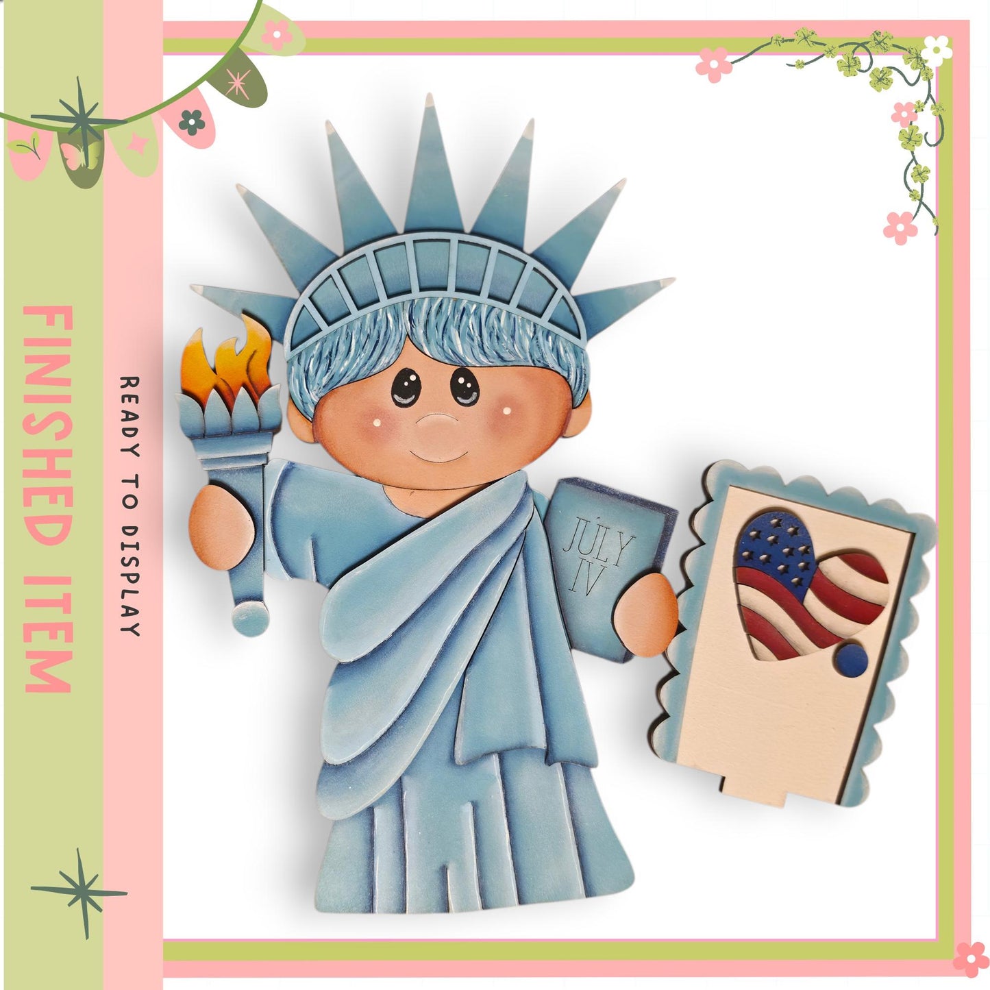 A wooden cutout of the Statue of Liberty, with a child figure holding a torch and a postcard featuring an American flag.