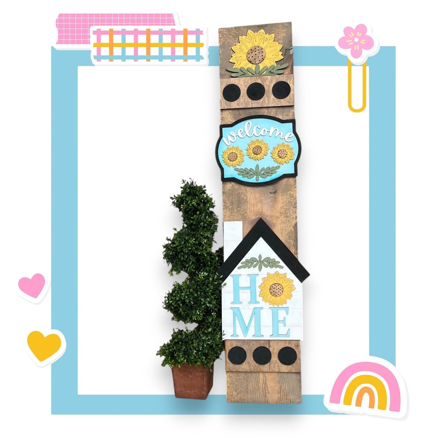 a picture frame with a house and sunflowers on it