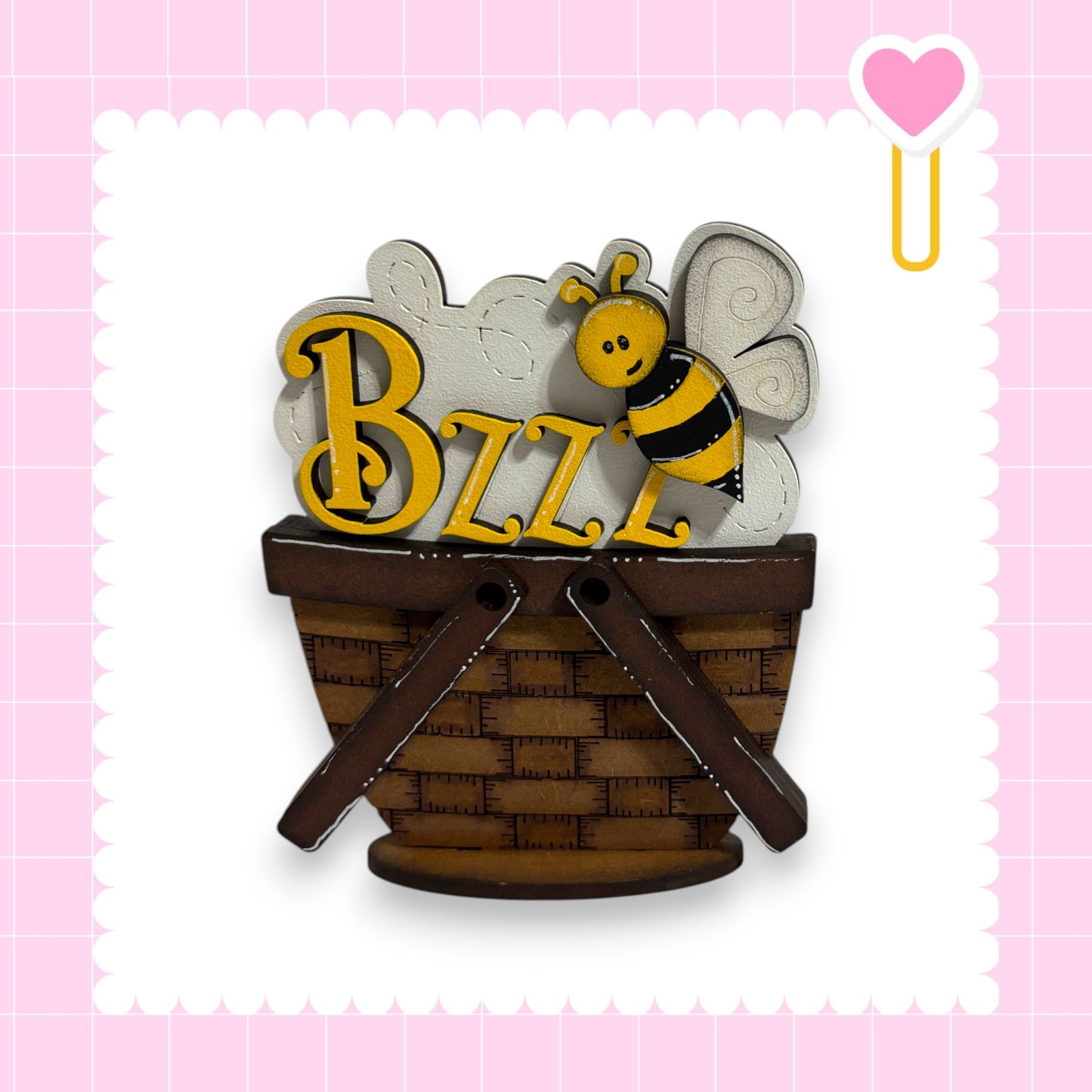 A wooden basket with a bee figure on top, and the word "BZZL" written on it.