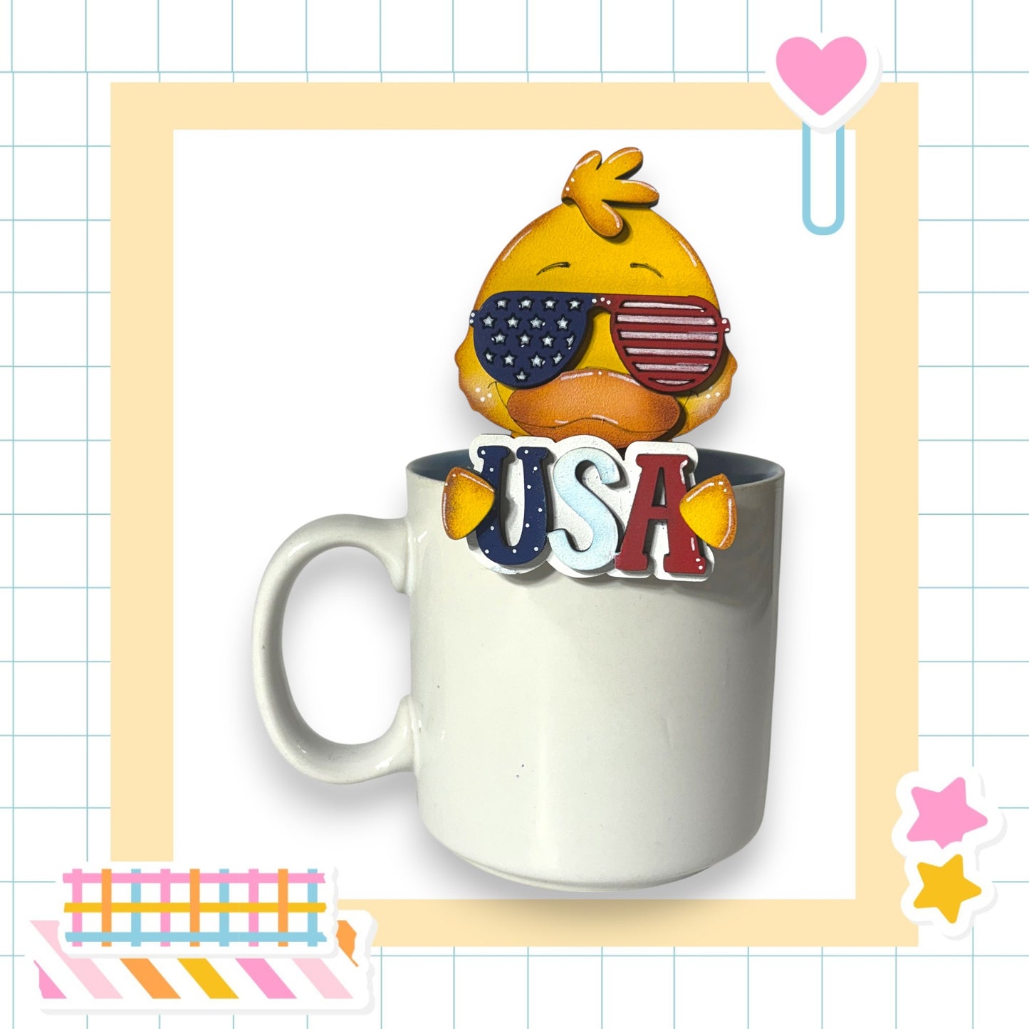 A cute cartoon bird wearing sunglasses and the word "USA" is sitting inside a white mug, surrounded by various colorful stickers and a heart-shaped object.