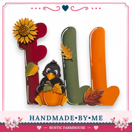 A hand-made wooden sign with the word "FALL" made up of colorful wooden letters, including a sunflower, a black bird, and autumn leaves.