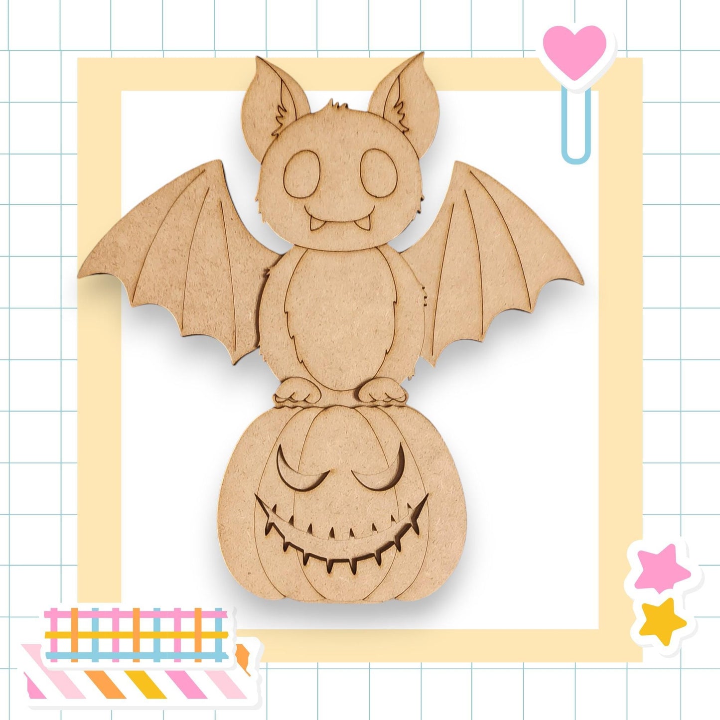 A wooden bat with a carved face is perched on a carved pumpkin, surrounded by colorful stickers and a heart-shaped object.
