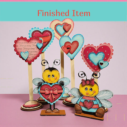 a collection of heart-shaped decorations, including wooden bee-shaped figures and other heart-themed items, arranged on a pink background.