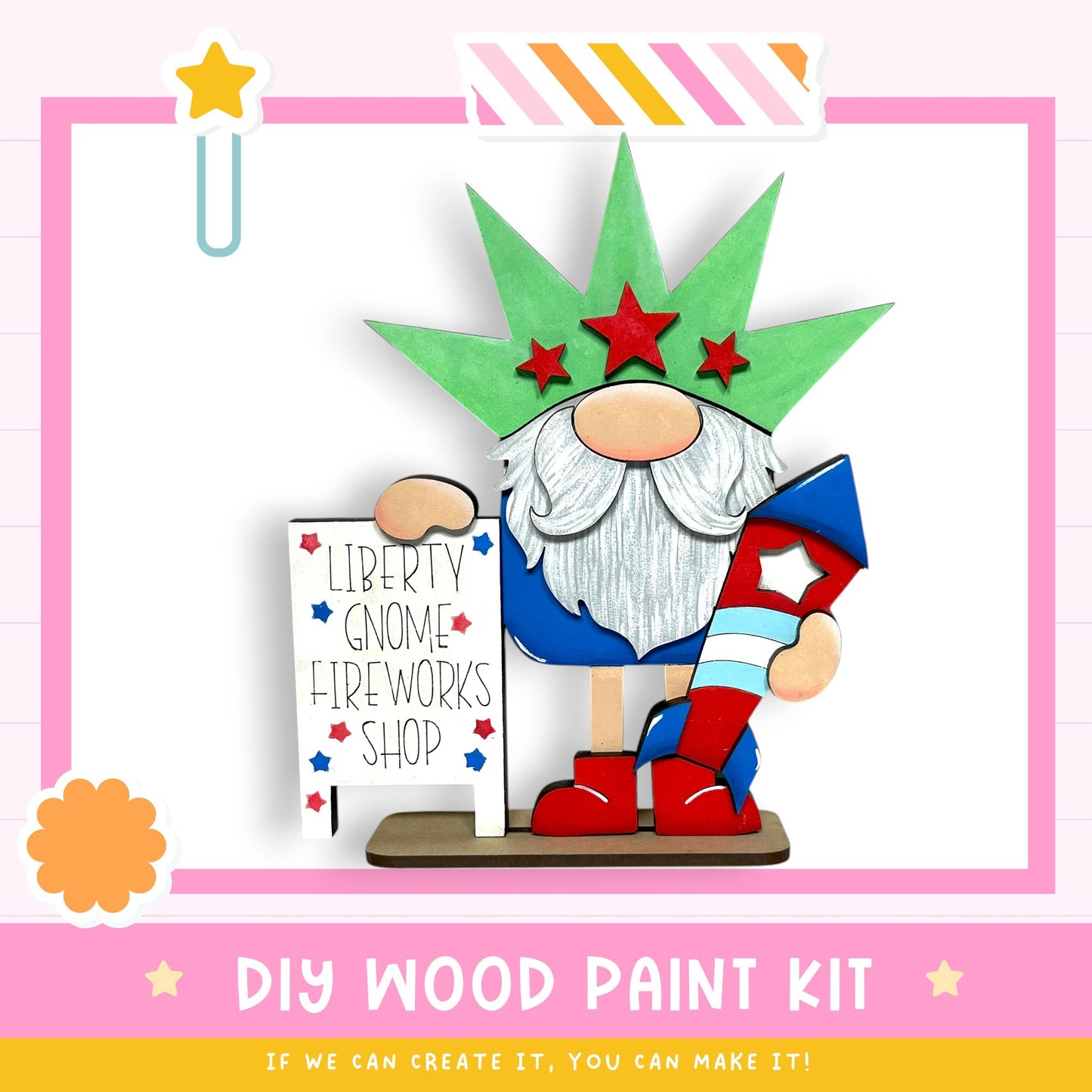A wooden gnome figurine holding a sign that says "Liberty Gnome Fireworks Shop" and wearing a green hat with red stars. The gnome is standing on a pink and white striped base, and there is a star decoration above the gnome. The image also includes text that says "DIY WOOD PAINT KIT" and "IF WE CAN CREATE IT, YOU CAN MAKE IT!"