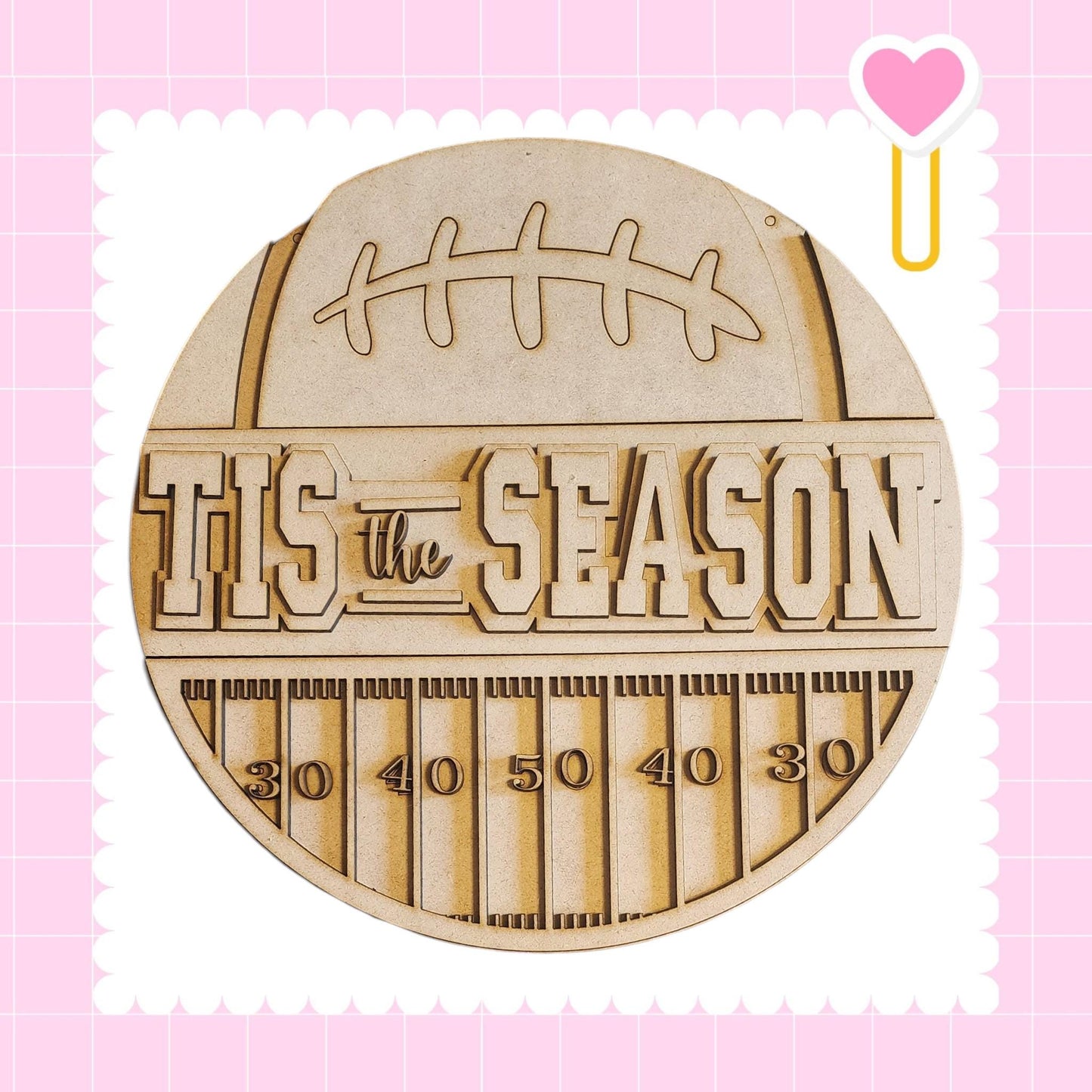 A wooden sign with the text "TIS THE SEASON" and a football graphic, surrounded by a grid pattern.