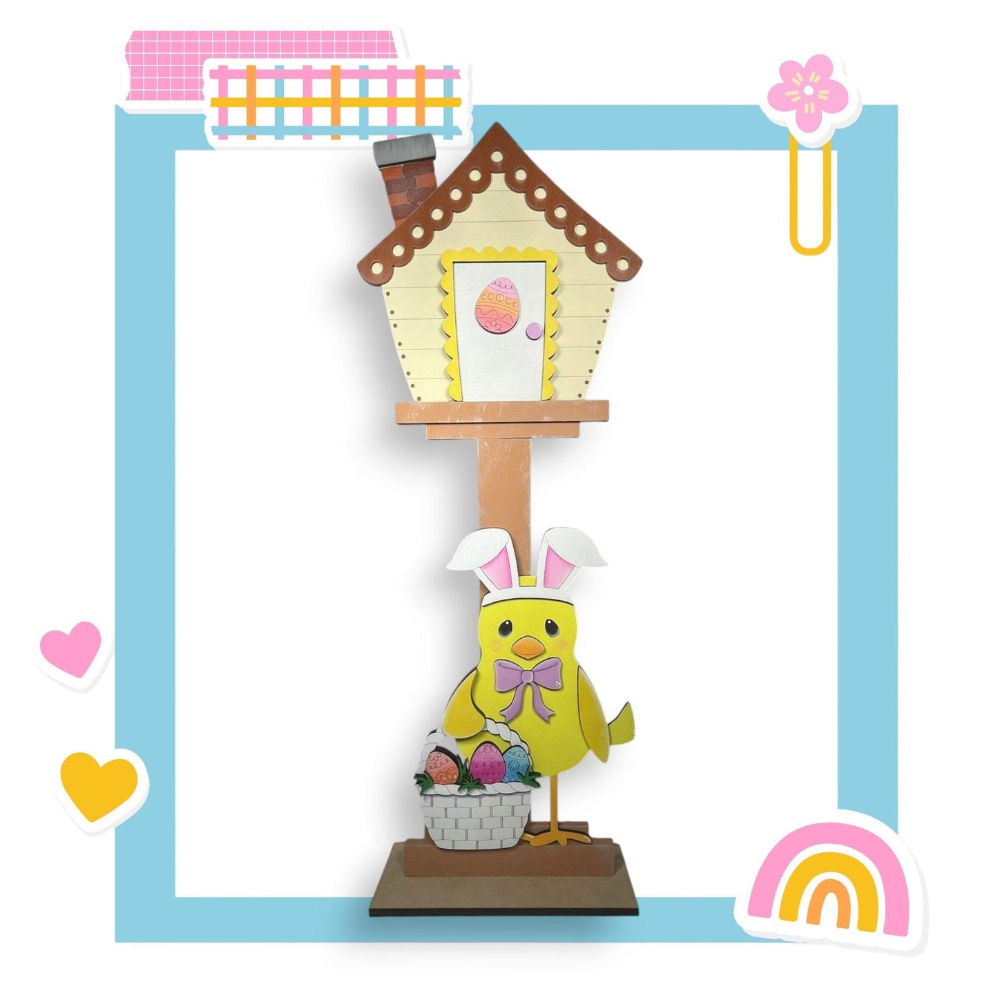 a paper cut out of a birdhouse with a chick and a basket of eggs