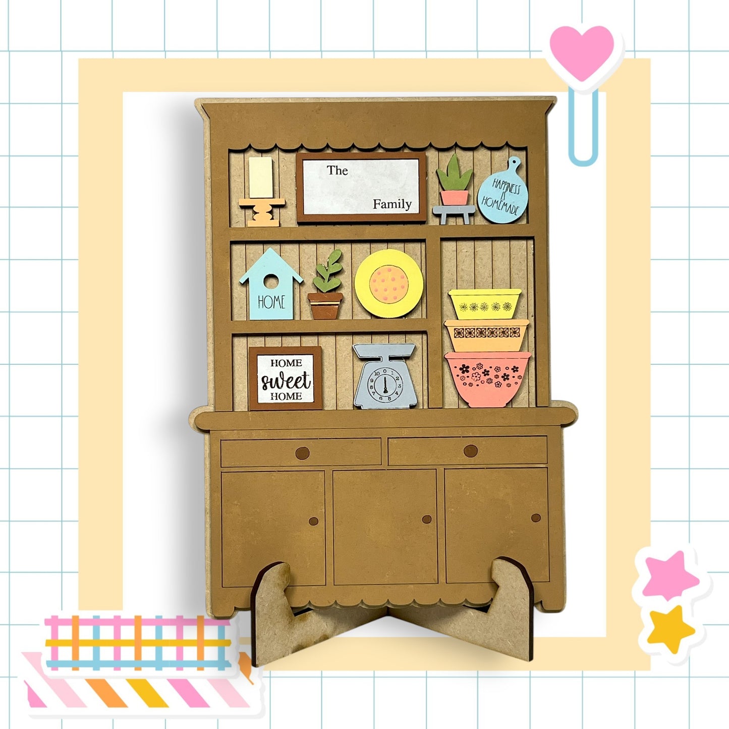 A wooden cabinet with various decorative items and a sign that reads "The Family" is displayed in the image.
