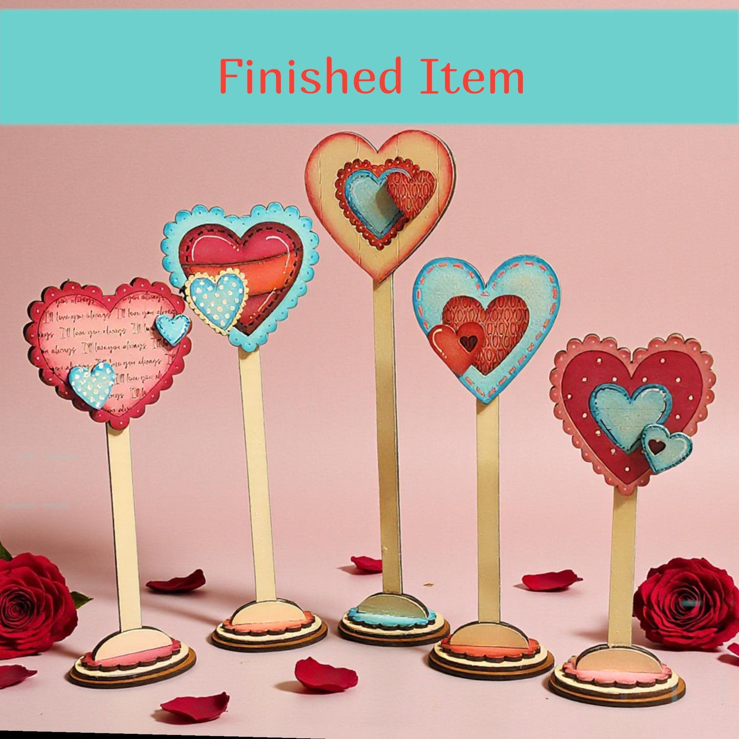 a collection of heart-shaped decorations, including paper cutouts and wooden stands, arranged on a pink background.