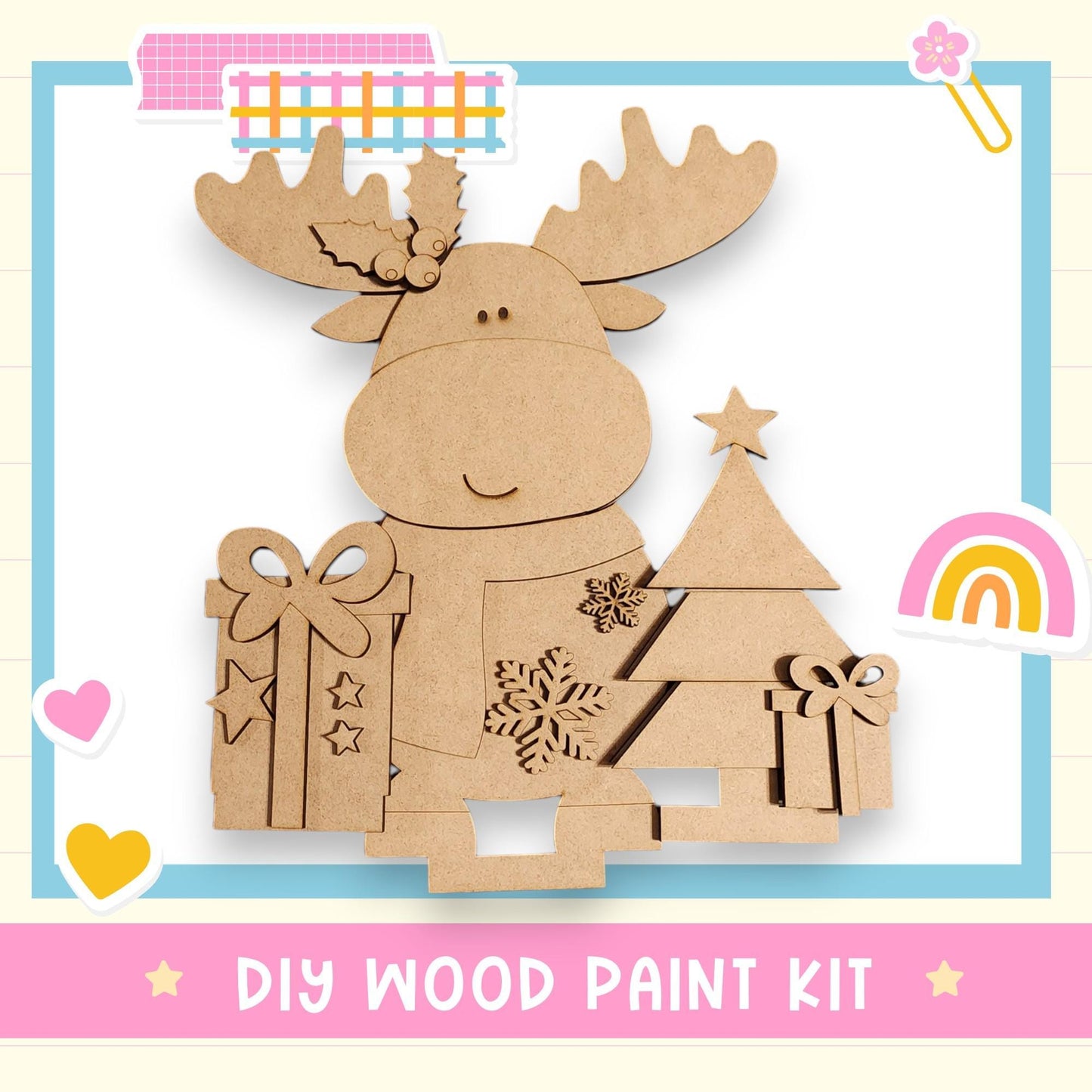 a DIY wood paint kit for creating a wooden Christmas tree decoration. The kit includes a wooden tree, a bow, and a star, all made of cardboard. The kit is presented in a pink and blue frame, with various decorative elements such as hearts and a rainbow.
