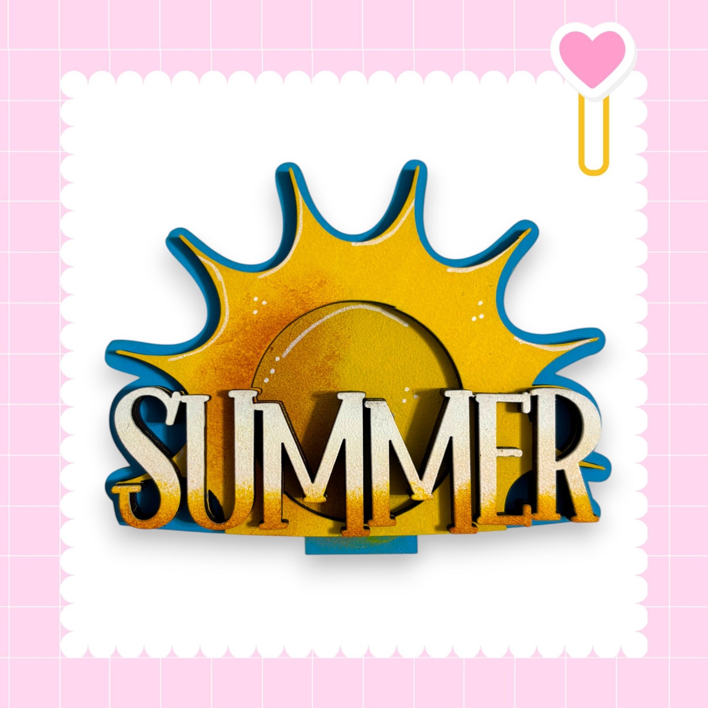 a sun-shaped object with the word "SUMMER" written on it, set against a pink background with a scalloped edge.