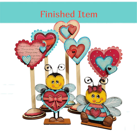 a collection of heart-shaped decorations, including wooden bee-shaped figures, arranged together.