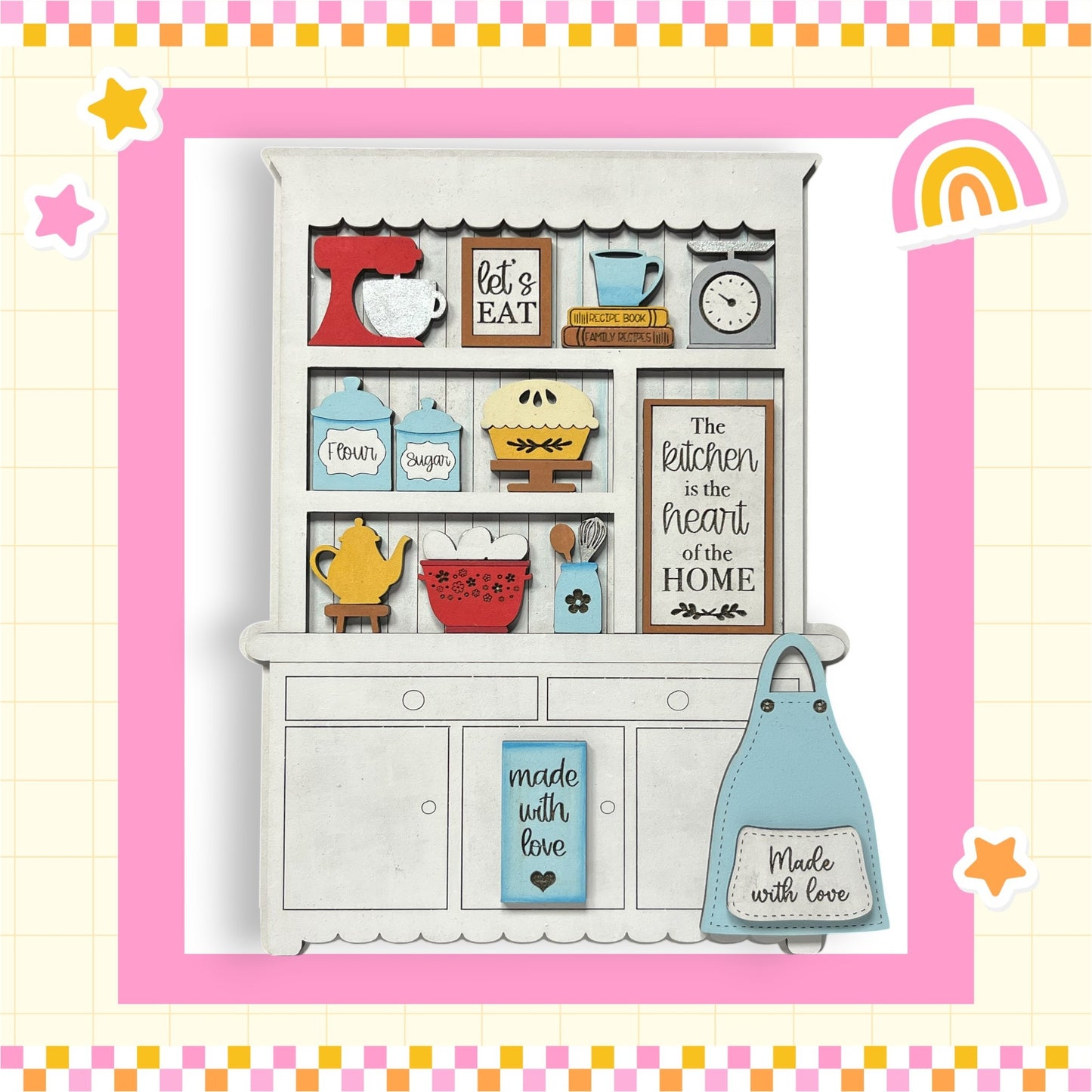 A wooden kitchen cabinet with various kitchen items and a sign that reads "The kitchen is the heart of the home".
