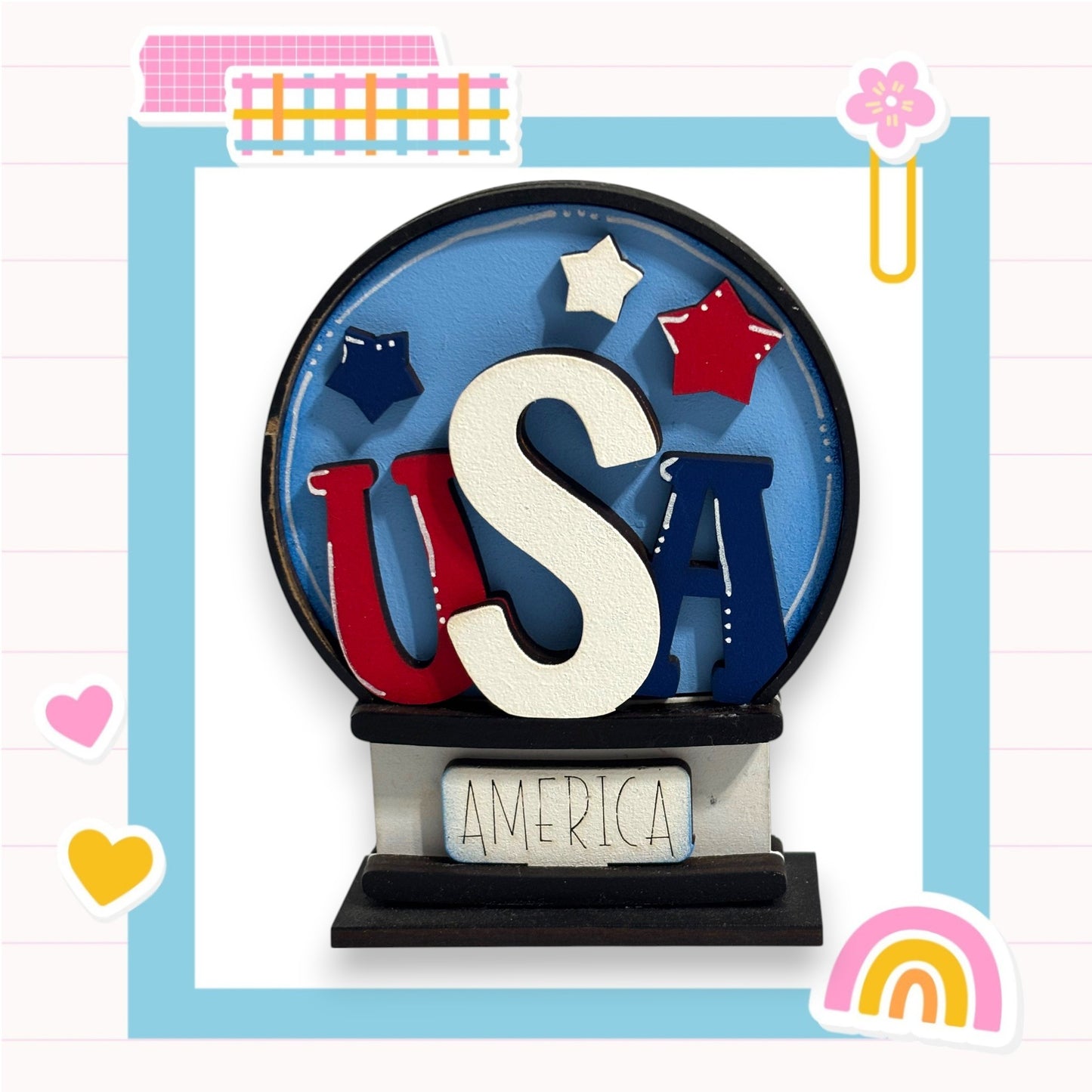 A colorful snow globe with the word "USA" prominently displayed in the center, surrounded by stars and hearts.
