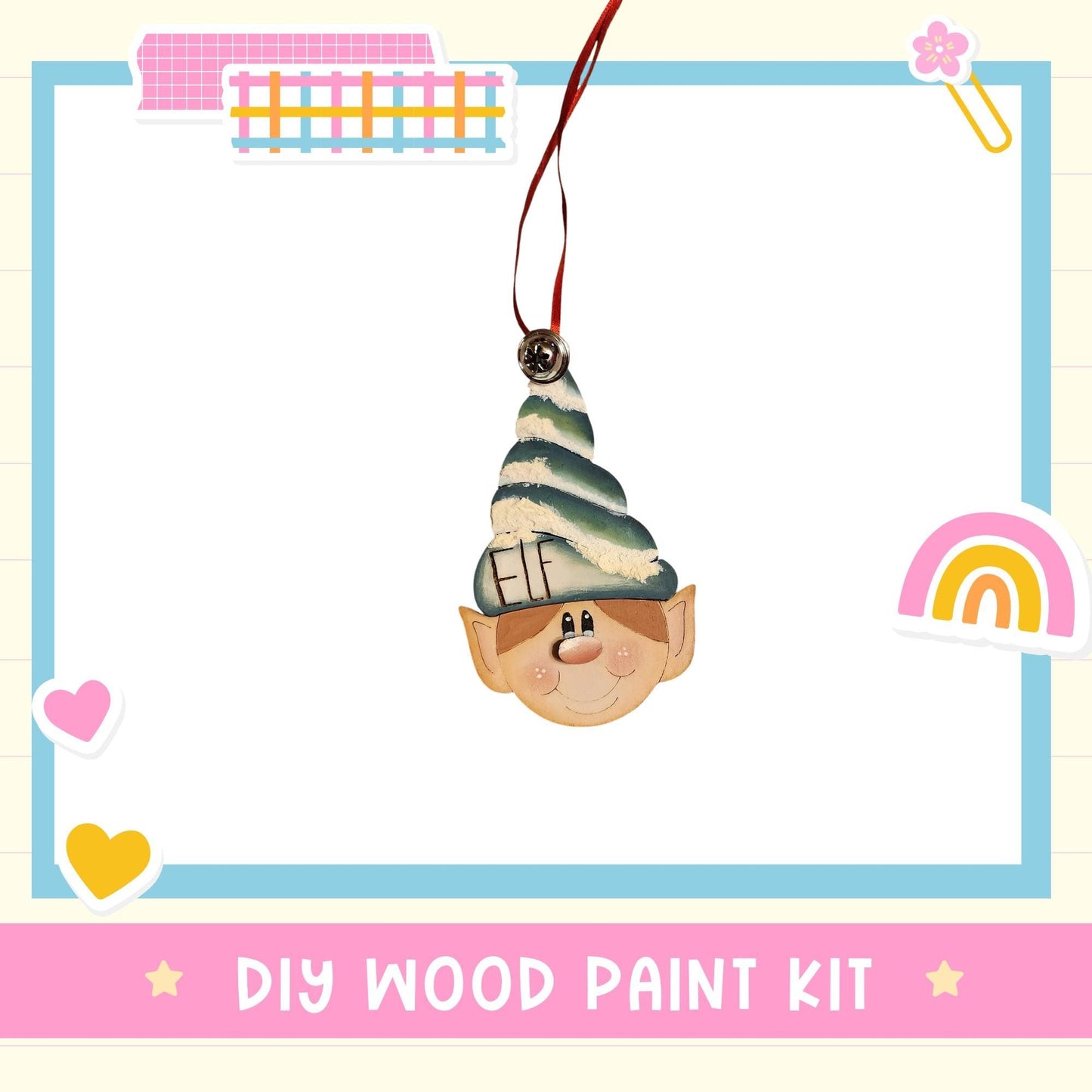 a DIY wood paint kit with a whimsical elf head ornament hanging from a string.