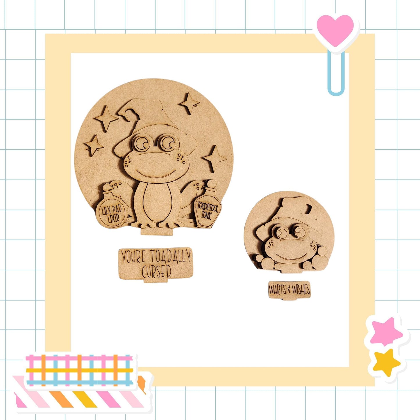 two wooden frog-shaped objects, one larger and one smaller, both with a mischievous expression. The larger frog is holding a bottle and a sign that says "You're Toadally Cursed", while the smaller frog is holding a sign that says "Warts & Wishes". The image also includes a heart-shaped object and some colorful stickers, creating a playful and whimsical atmosphere.