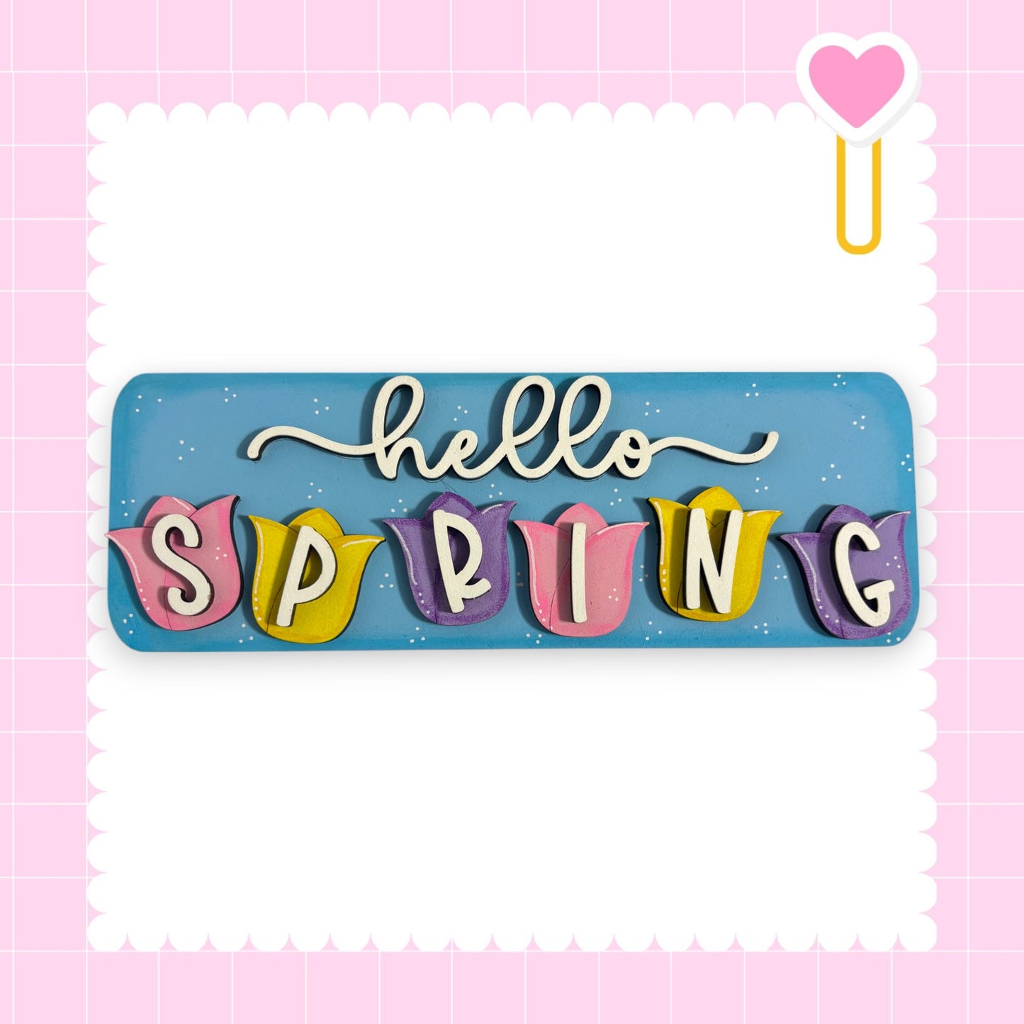 A colorful sign with the word "SPRING" written on it, surrounded by decorative elements such as hearts and flowers.