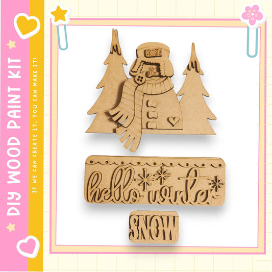 a DIY paint kit for creating a snowman, with a wooden snowman and a snowman-shaped cutout. The kit includes a snowman cutout and a snowman-shaped cutout, both made of wood. The kit also includes a wooden snowman cutout and a snowman-shaped cutout. The kit is designed for creating a winter scene with a snowman and a snowman.