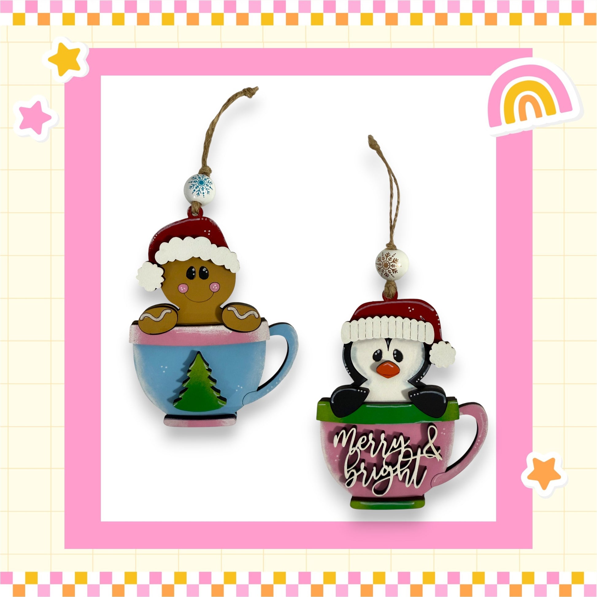 two Christmas ornaments, each shaped like a mug. One mug is decorated with a gingerbread man wearing a Santa hat, and the other mug has a penguin wearing a Santa hat. The ornaments are hanging from strings and are part of a festive holiday display.