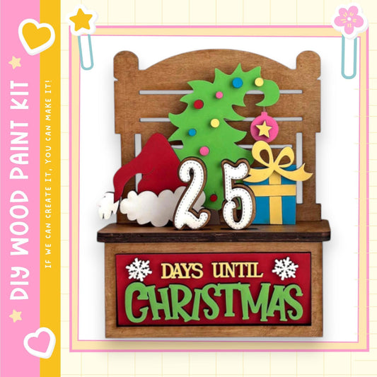 A wooden paint kit with a Christmas-themed design, including a tree, gift, and a sign that says "25 DAYS UNTIL CHRISTMAS".