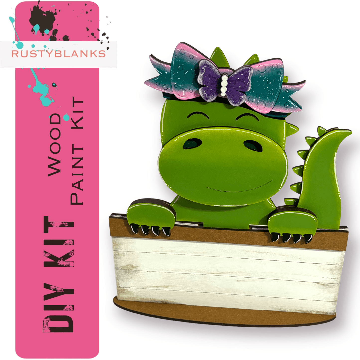 a green dinosaur with a bow sitting in a box