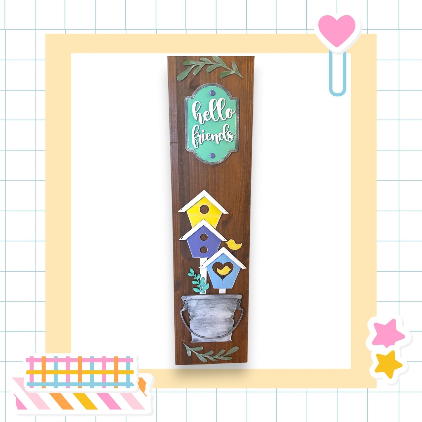 a wooden sign with a birdhouse design, surrounded by various decorative elements such as a heart, stars, and a pink heart.