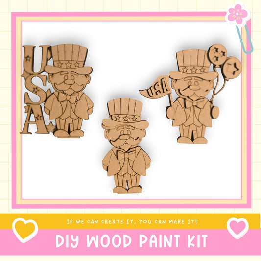 The image is a collage of three wooden figures, each wearing a top hat and waving a flag that says "USA". The text "DIY WOOD PAINT KIT" is displayed at the bottom of the image.