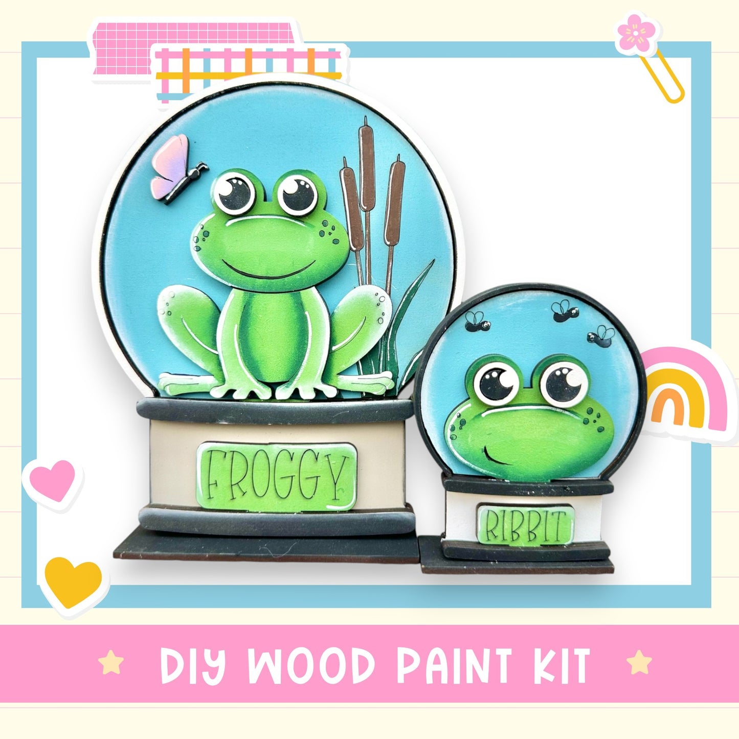 a DIY wood paint kit for creating a frog-themed snow globe. The kit includes a frog figurine and a snow globe, both of which are designed to resemble a frog. The kit is presented in a pink and blue color scheme, with the frog figurine and snow globe being the main focus of the image.