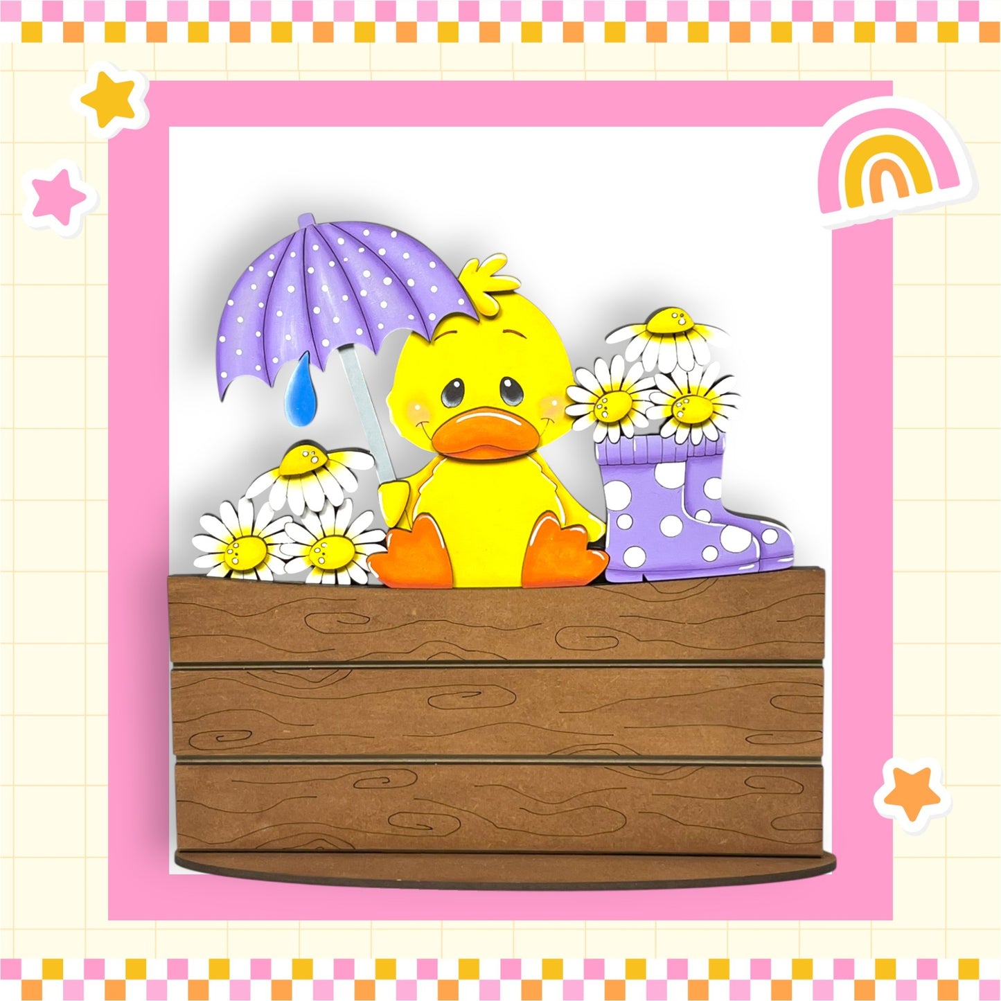 A yellow duck holding a purple umbrella and surrounded by white daisies and purple polka dot boots, sitting on a wooden bench.