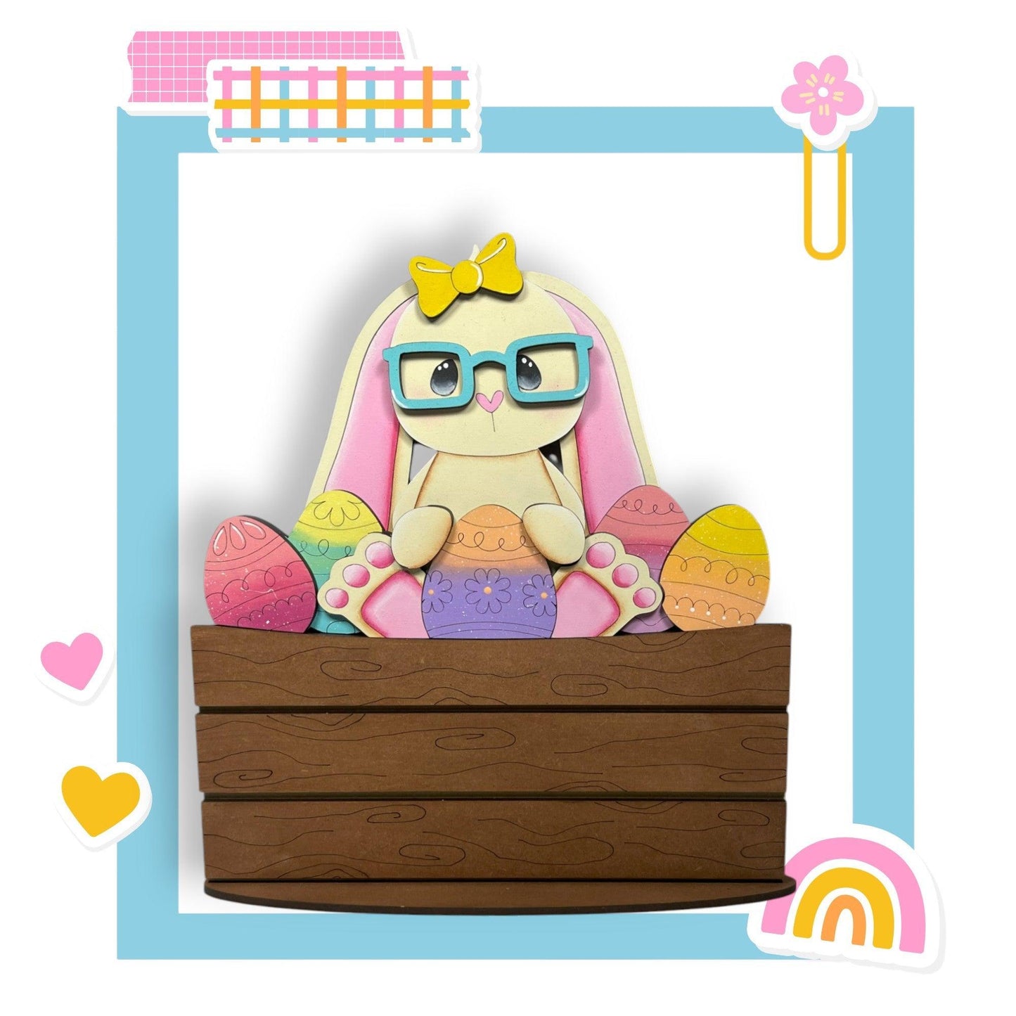 a paper cut of a bunny with glasses sitting in a wooden box
