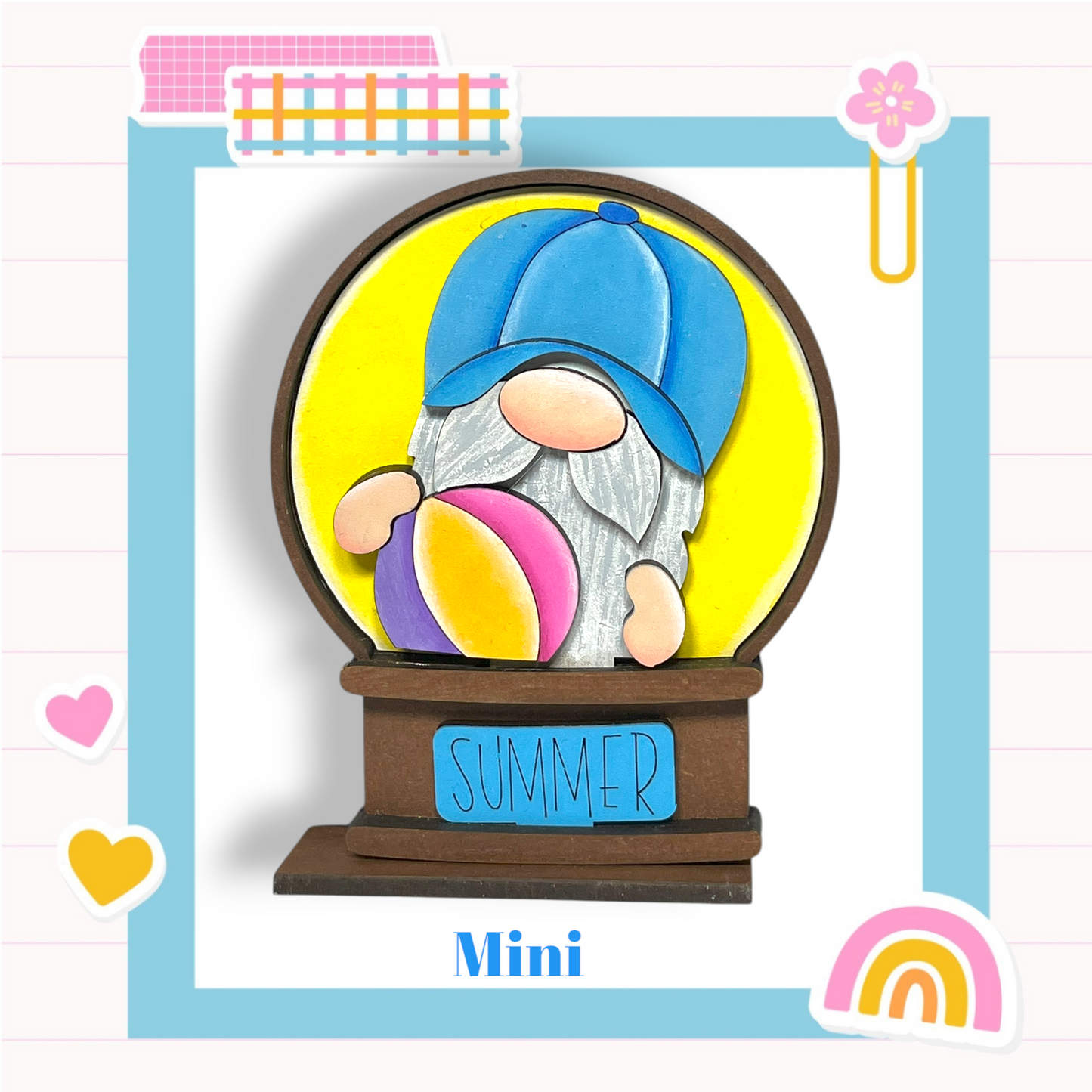 A gnome figurine wearing a blue hat and holding a beach ball, with the word "SUMMER" written on a sign below the gnome.