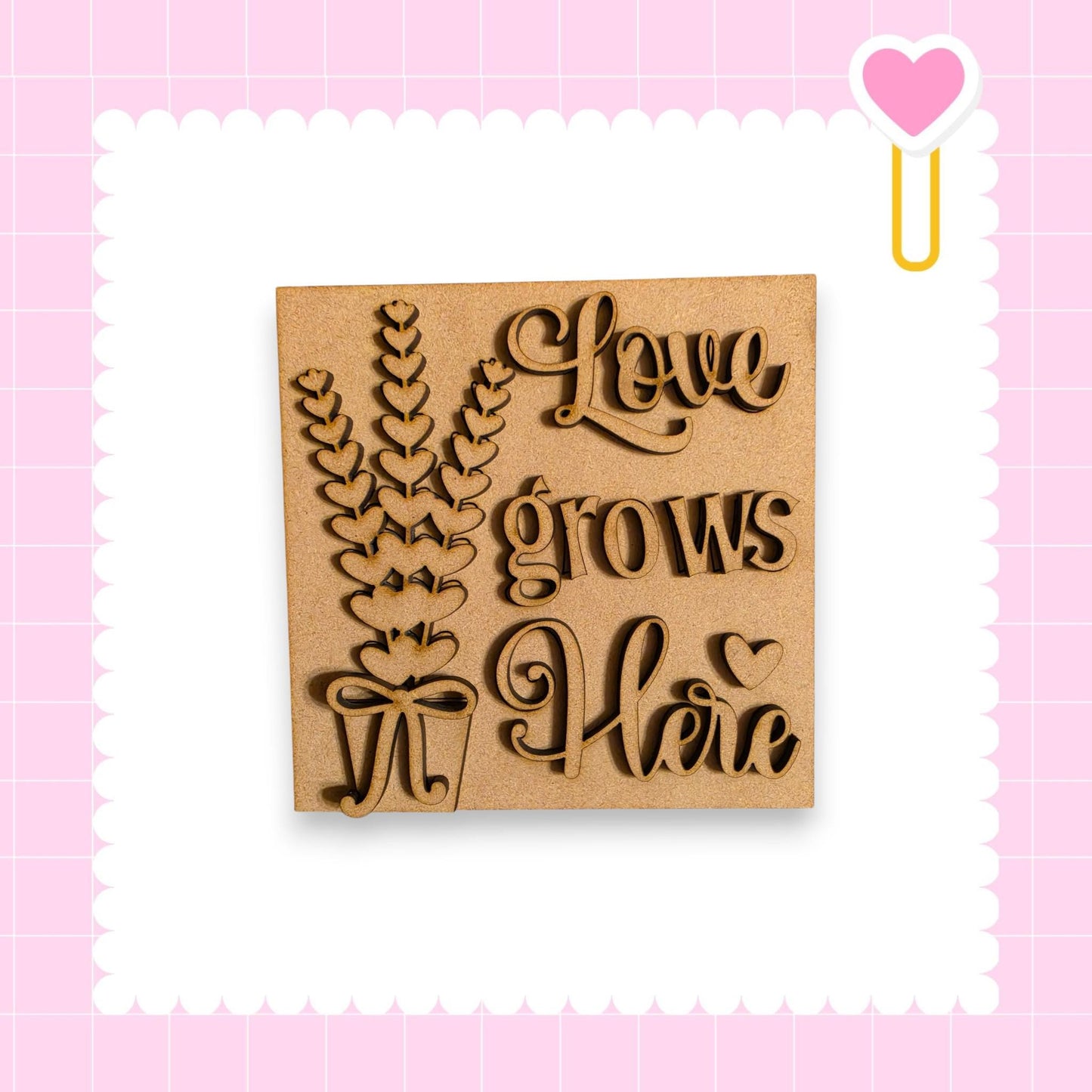 a wooden sign with the text "Love grows here" carved into it, surrounded by a decorative border.