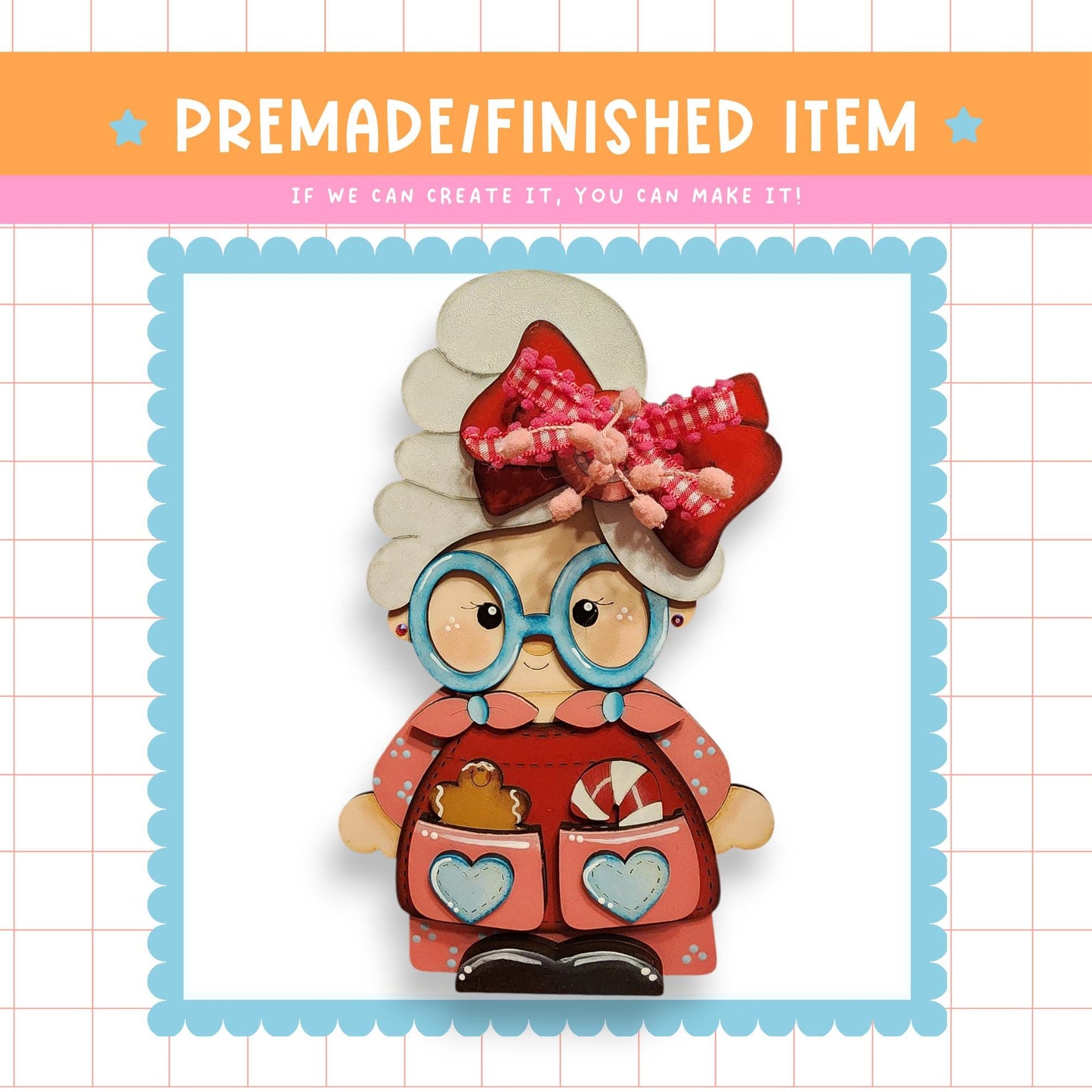a wooden doll with a red dress, a bow, and glasses, sitting in a pink and blue frame.