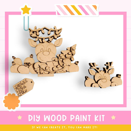 a DIY wood paint kit for creating wooden reindeer ornaments. The kit includes two wooden reindeer figures, one larger and one smaller, as well as a label that reads "Santa's Night Crew". The kit appears to be designed for children to engage in a creative and fun activity.