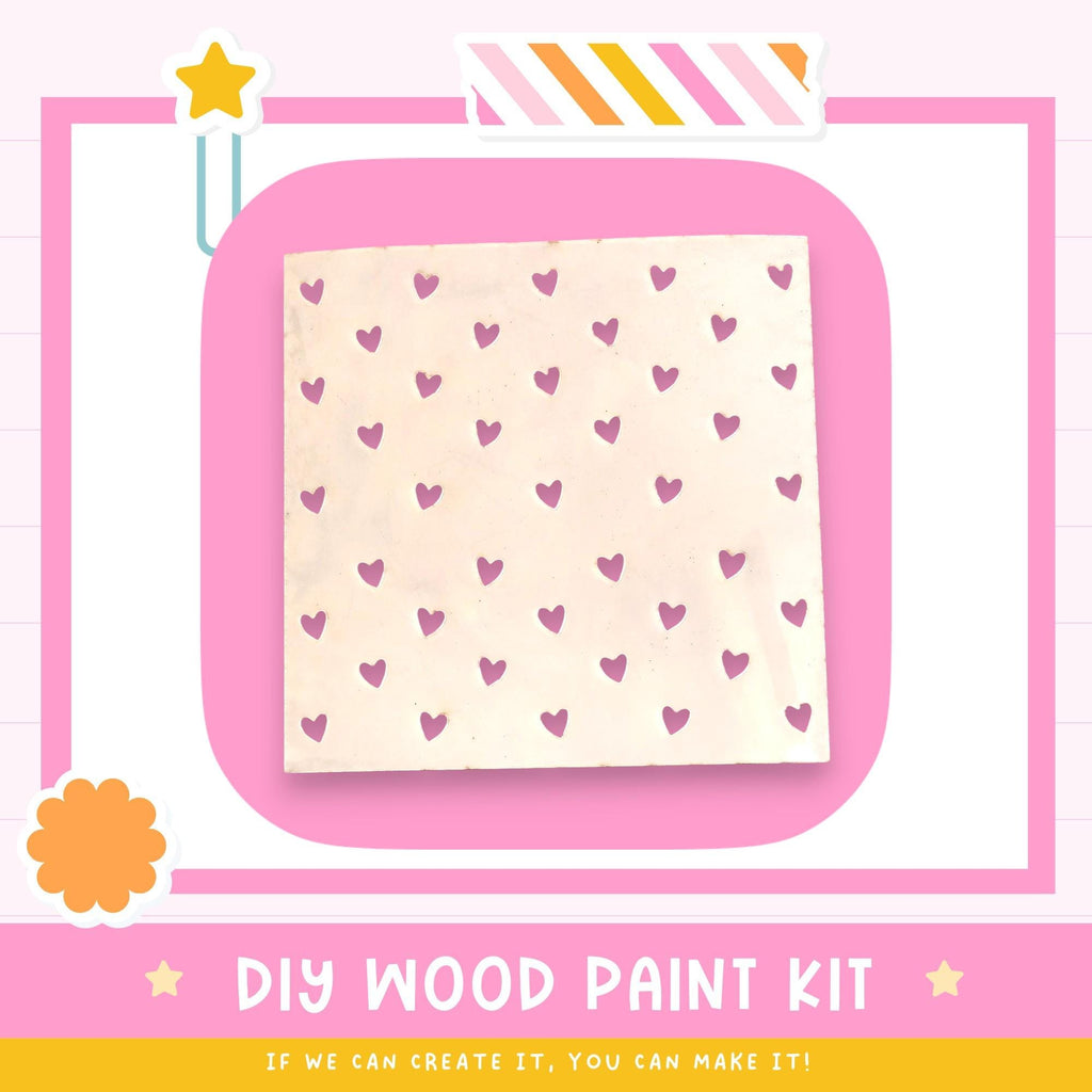 The image is a DIY wood paint kit advertisement, featuring a pink background with a white square containing a pattern of pink hearts. The text below the image encourages viewers to "If we can create it, you can make it!"