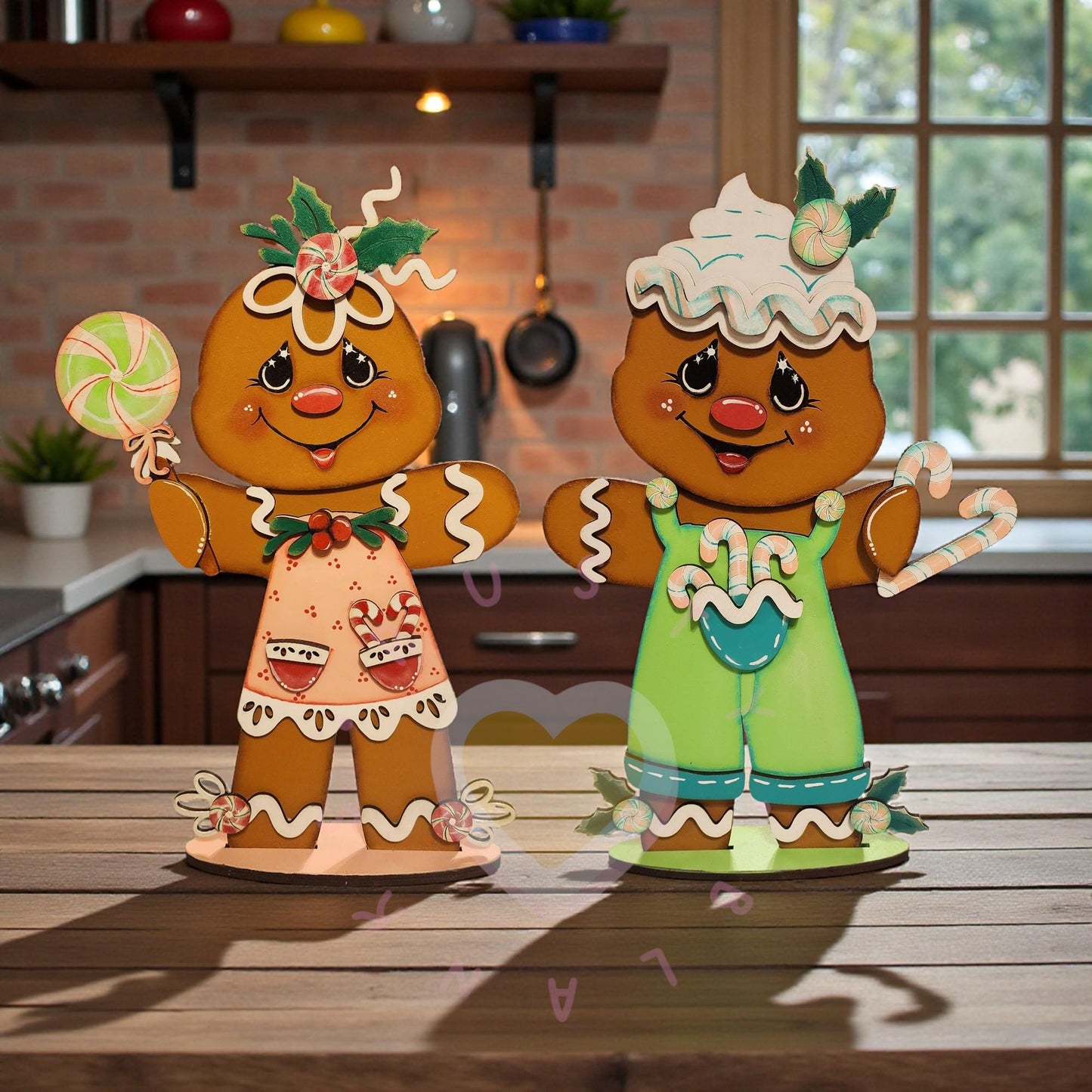 Two gingerbread man figurines, one wearing a pink dress and the other wearing green overalls, standing on a wooden surface.