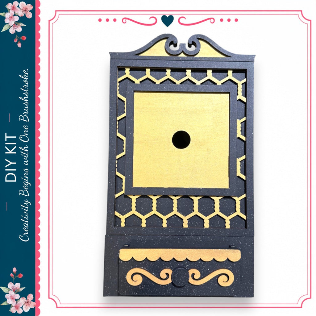 a decorative black and gold box with a gold-colored hole in the center.