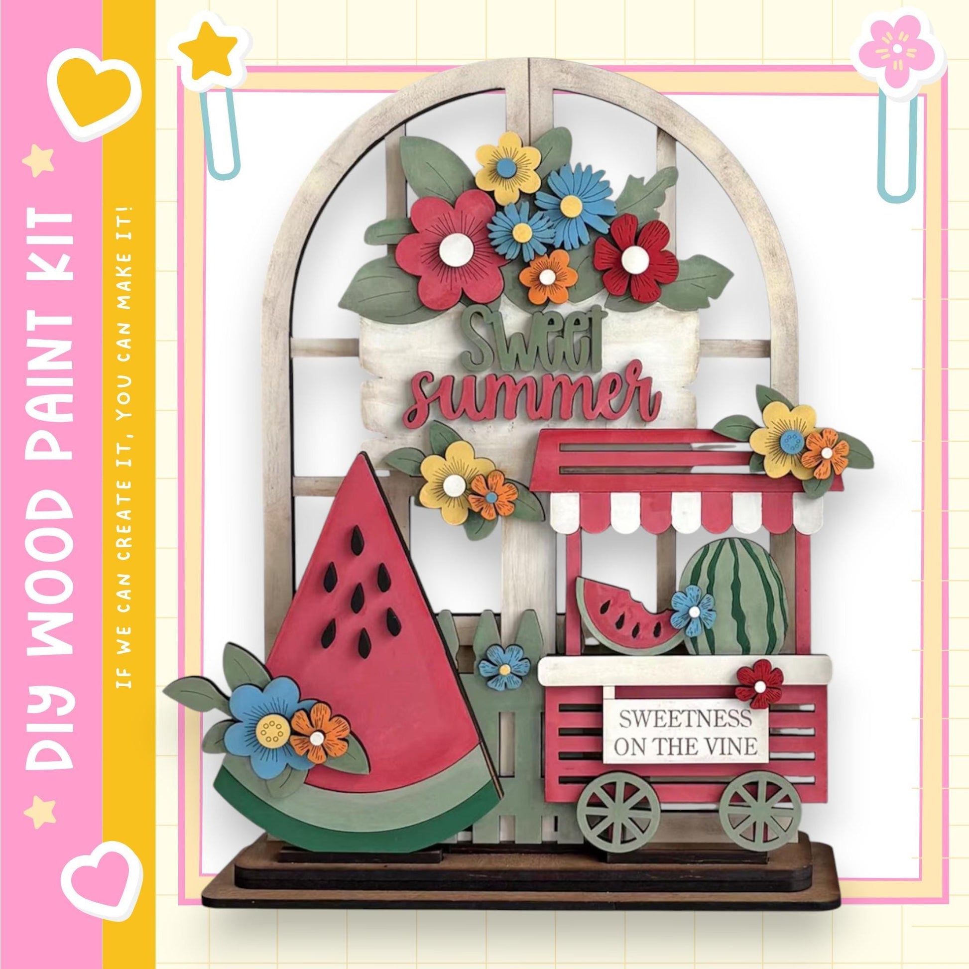 The image is a colorful and whimsical display featuring a wooden wagon, a watermelon, and various flowers and leaves. The wagon is decorated with a sign that reads "Sweet summer" and has a "Sweetness on the vine" sign on it. The overall scene is vibrant and cheerful, with the wagon and wagon cart as the main focal points.