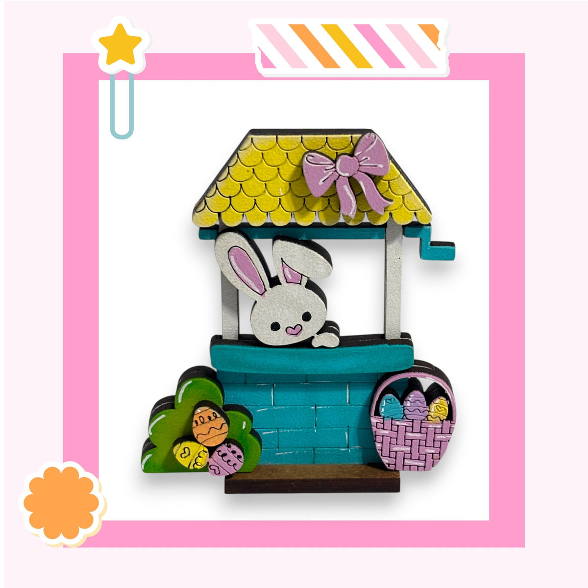 A wooden toy house with a bunny inside, decorated for Easter.