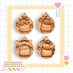 four wooden ornaments with various designs, including a snowman, reindeer, cat, and other festive elements, all set against a yellow and white checkered background.