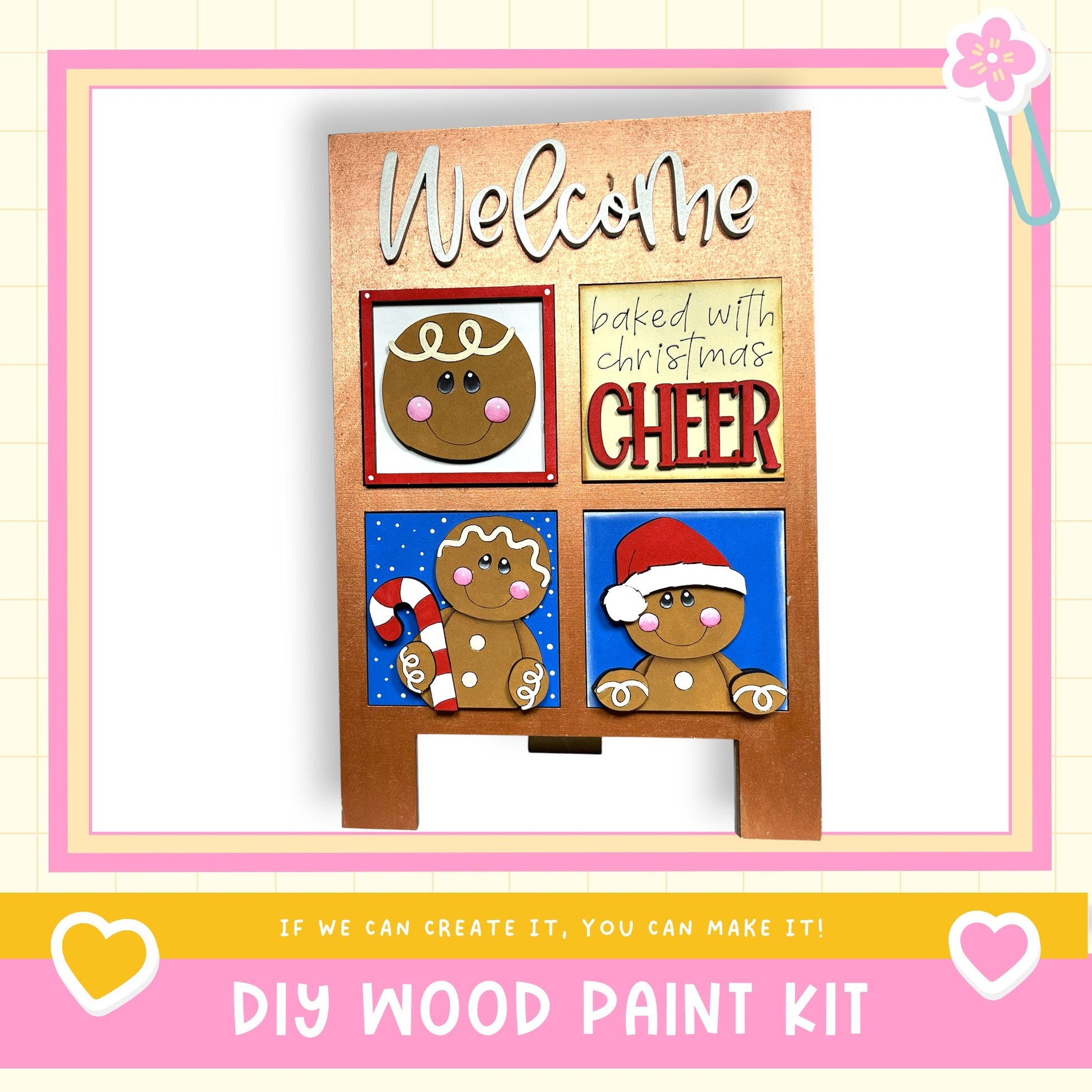 The image is a DIY wood paint kit featuring a welcome sign with gingerbread man and a cheer sign, along with a heart and a flower.