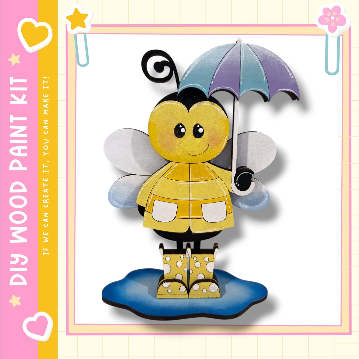 A cheerful yellow bee holding an umbrella and wearing rain boots stands on a puddle, surrounded by a pink and yellow border with hearts and stars.